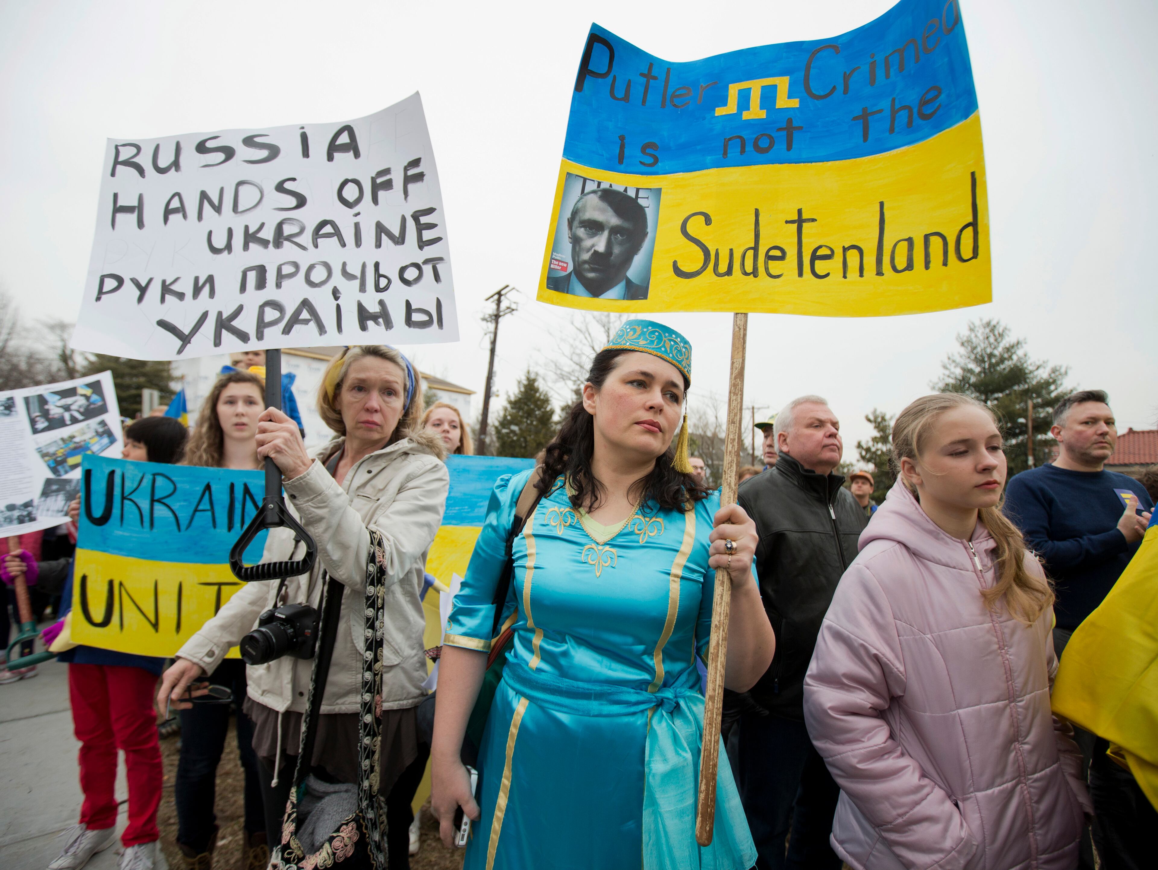 Velida Kent, second form right, whose family originated from Crimea, wears her native Crimean Tatar outfit, during a protest rally in front of the Russian embassy, in Washington, Sunday, March 2, 2014. Igniting a tense standoff, Russian forces surrounded a Ukrainian army base Sunday just as the country began mobilizing in response to the surprise Russian takeover of Crimea. Outrage over Russia's tactics mounted in world capitals, with U.S. Secretary of State John Kerry calling on President Vladimir Putin to pull back from "an incredible act of aggression." (AP Photo/Manuel Balce Ceneta)