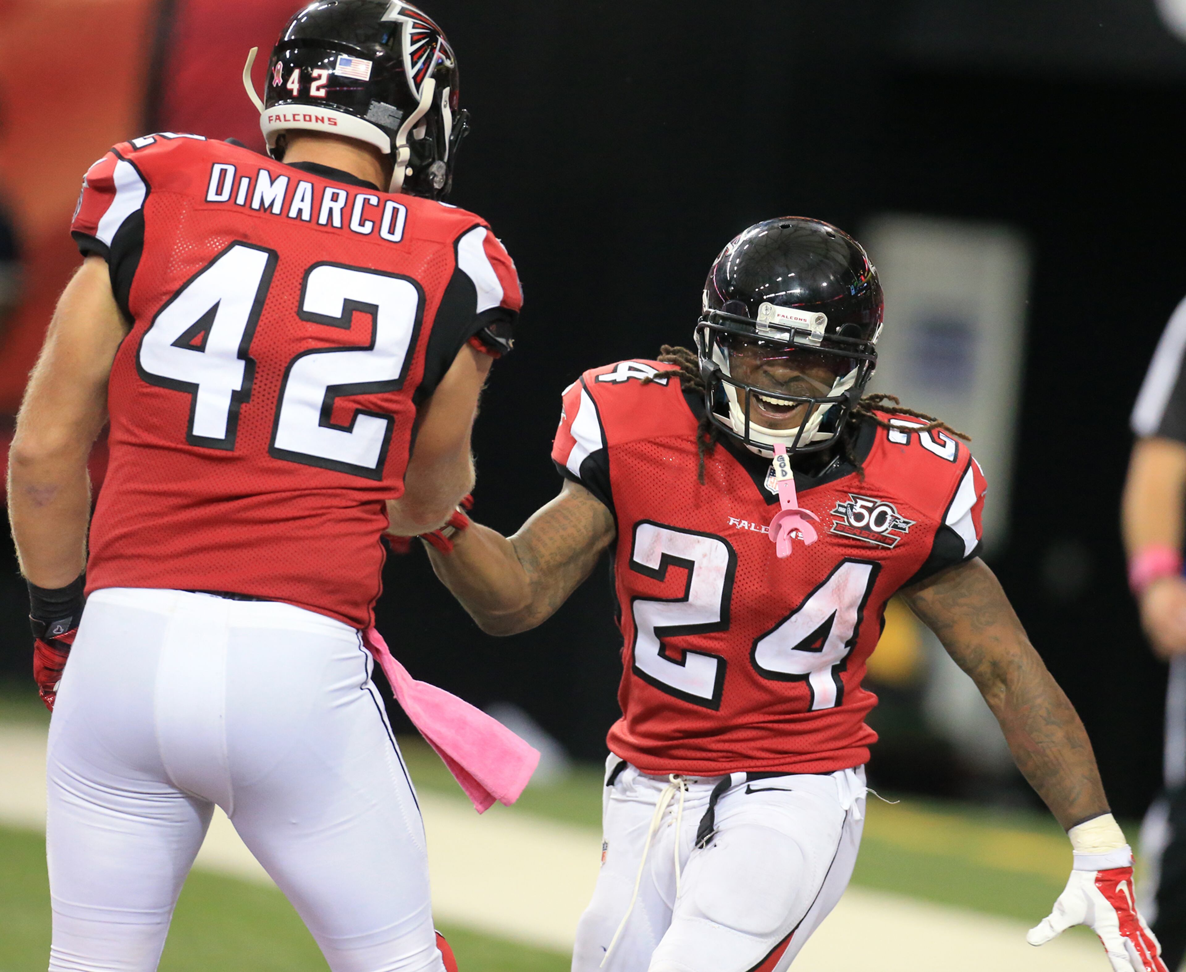 Falcons running back Devonta Freeman (right) celebrates his third touchdown of the day with Patrick DiMarco for a 35-0 lead during the third quarter in a football game on Sunday, Oct. 4, 2015, in Atlanta. The Falcons beat the Texans 48-21.