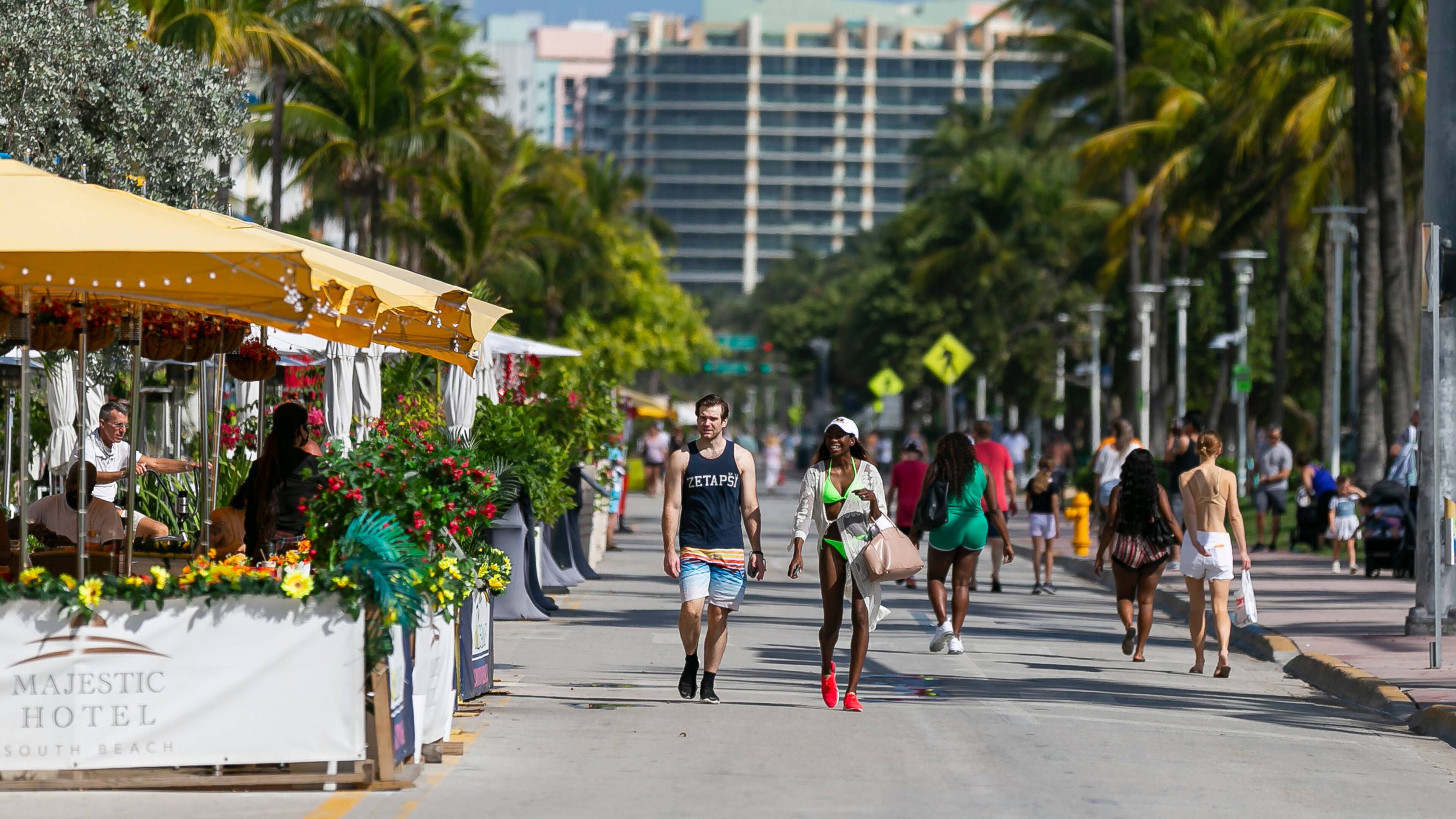 Pedestrians make their way down Ocean Drive in Miami Beach, Florida. To help address climate change, city leaders will cut back on the number of new palm trees in the city and add more shade trees to the Beach's canopy. (Matias J. Ocner/Miami Herald/TNS)