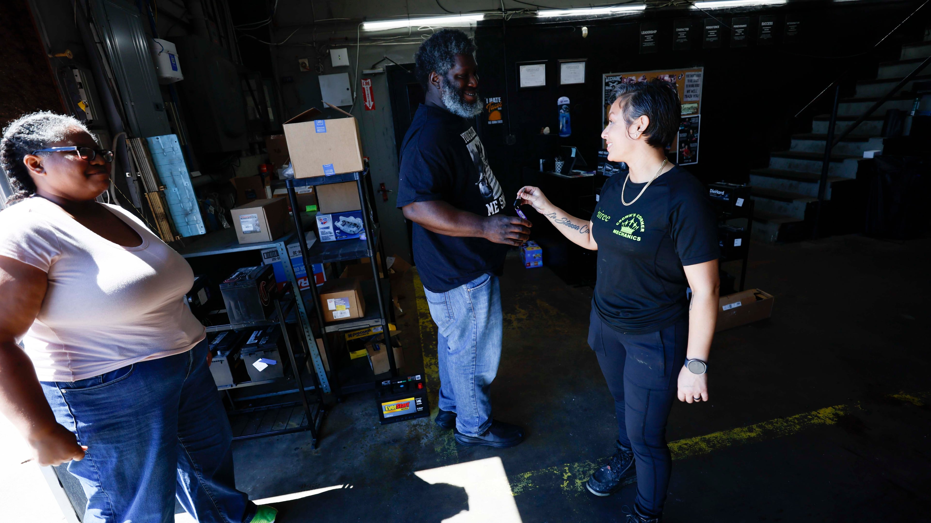Desiree White, owner of Crown’s Corner Mechanics, hands car keys to Brian and Crystal Sankfield, who express happiness about their car being repaired on time on Thursday, June 4, 2026. (Miguel Martinez/AJC)