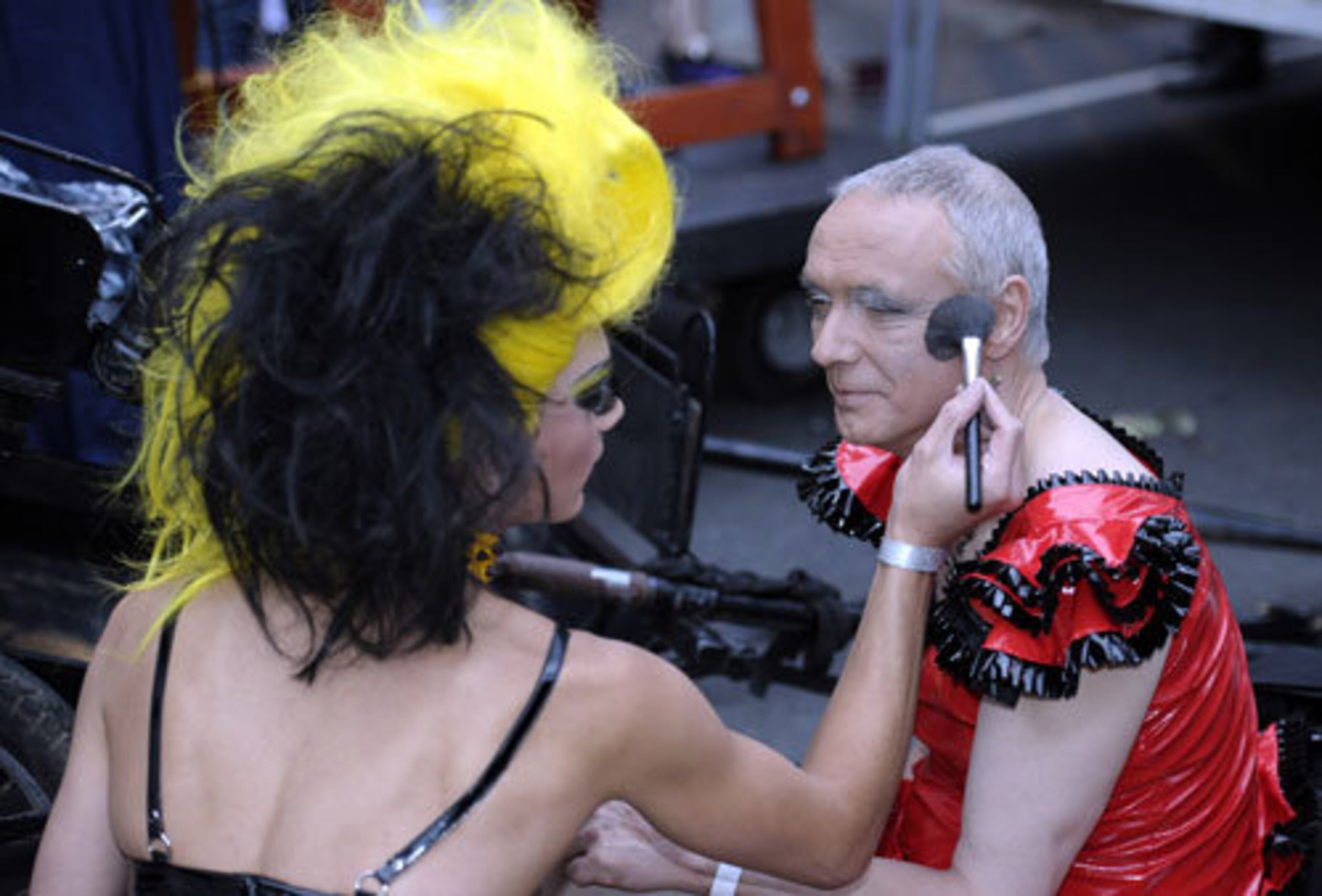 A woman does a few last minute make-up touch ups on a drag queen before the 2011 Gay and Lesbian Mardi Gras.
