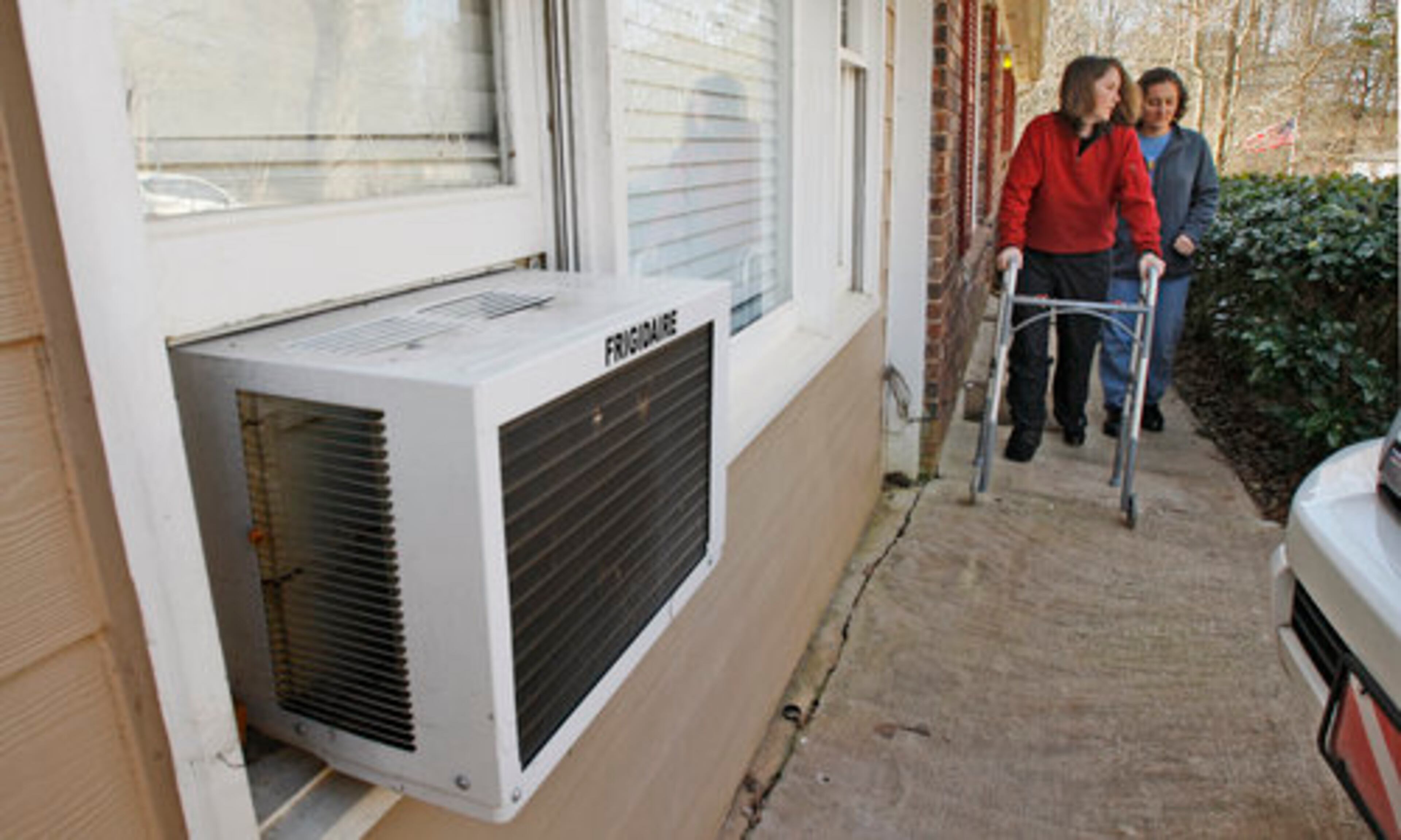 The window to the room they were shot in (foreground) has been repaired as Dackri Davis (left) and her roommate, Danielle LeBurn (right) leaves their home Friday, Feb. 26, 2010 for a doctor's appointment.