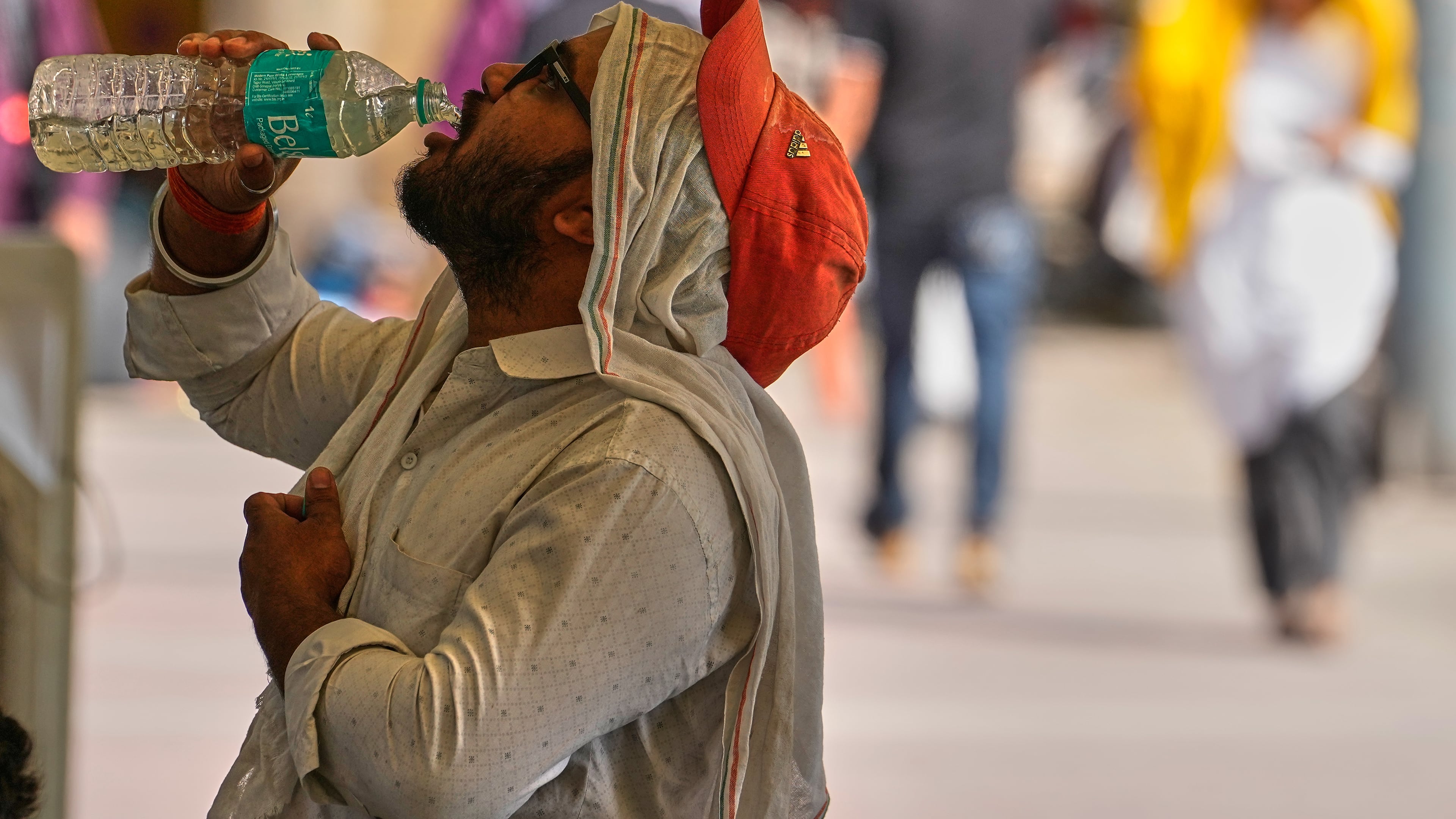 A commuter drinks water on a hot afternoon in New Delhi, India, Wednesday, May 20, 2026. (AP Photo/Manish Swarup)