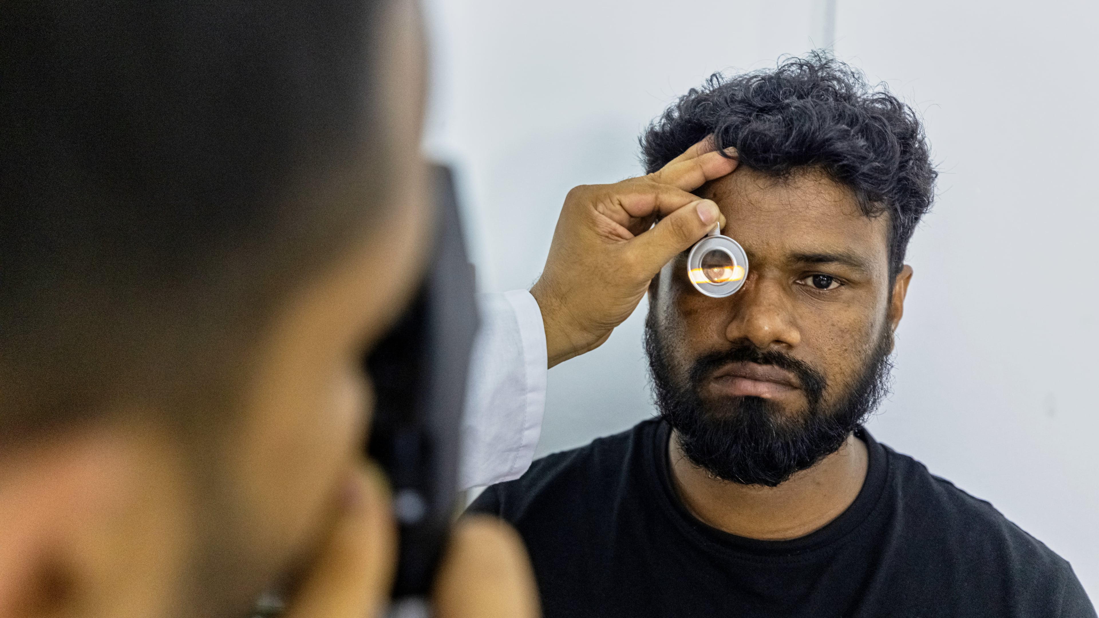 An eye care professional from VisionSpring examines a worker at a garment factory in Gazipur, on the outskirts of Dhaka, Bangladesh, June 30, 2026. (AP Photo/Rajib Dhar)