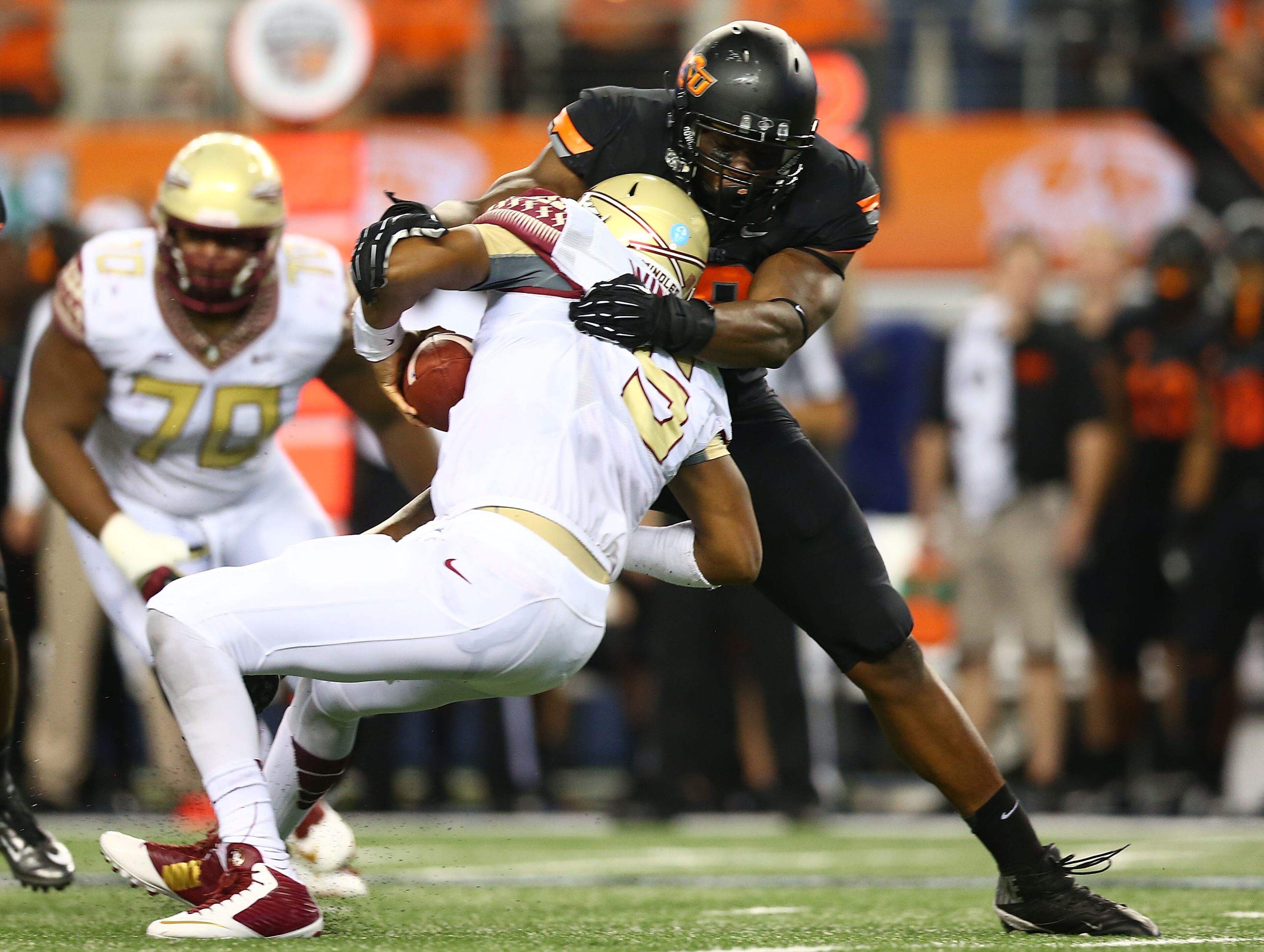 Jameis Winston of Florida State is sacked by Emmanuel Ogbah of Oklahoma State in the Advocare Cowboys Classic at AT&T Stadium on August 30, 2014 in Arlington, Texas. (Photo by Ronald Martinez/Getty Images)