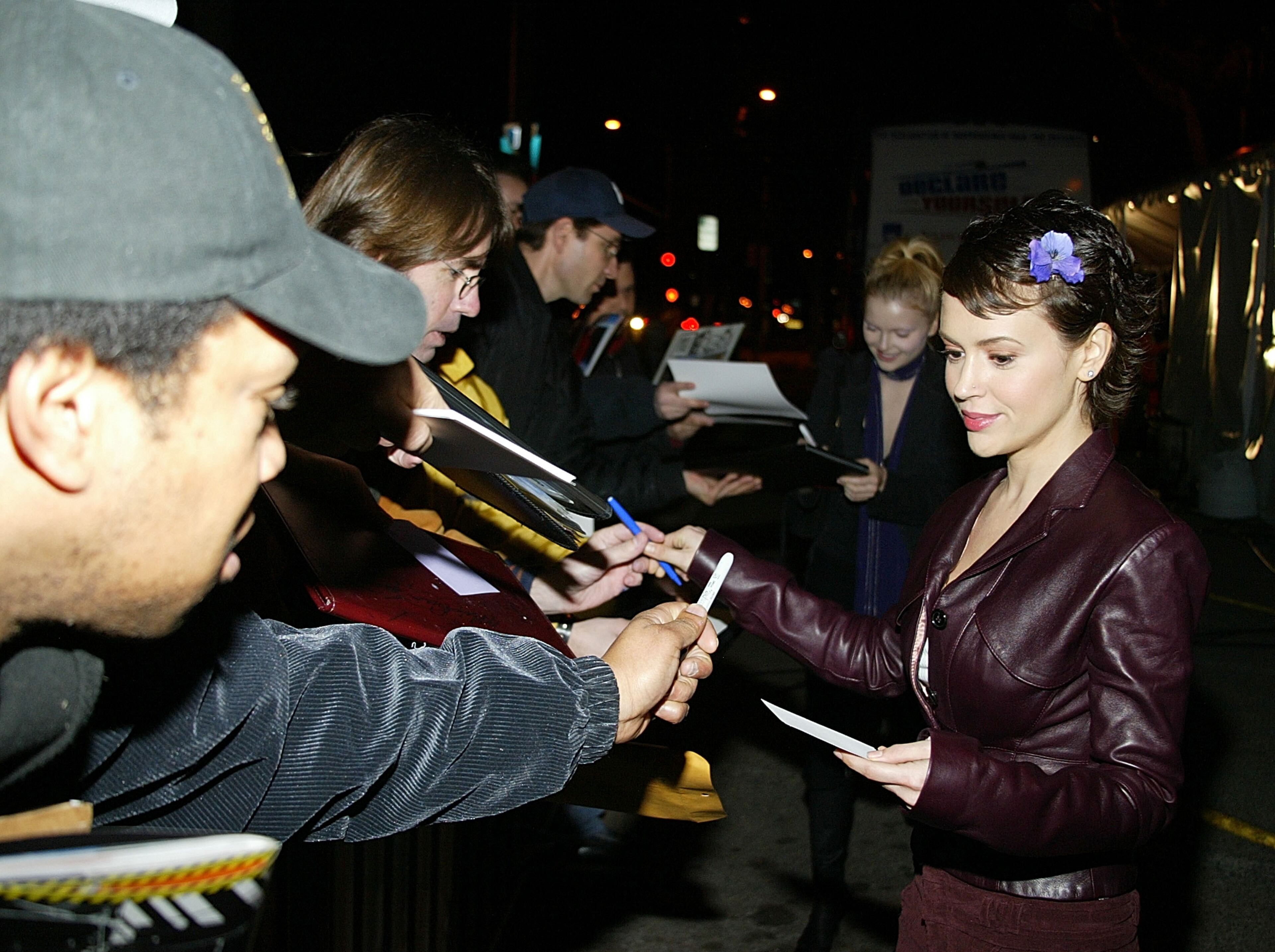 Alyssa Milano signs autographs as she arrives for the party for Norman Lear's "Declare Yourself" event March 2, 2004 in Beverly Hills, California. 'Declare Yourself' is a national nonpartisan, nonprofit campaign to inspire a new movement of young adults to participate in the 2004 election. (Photo by Carlo Allegri/Getty Images)