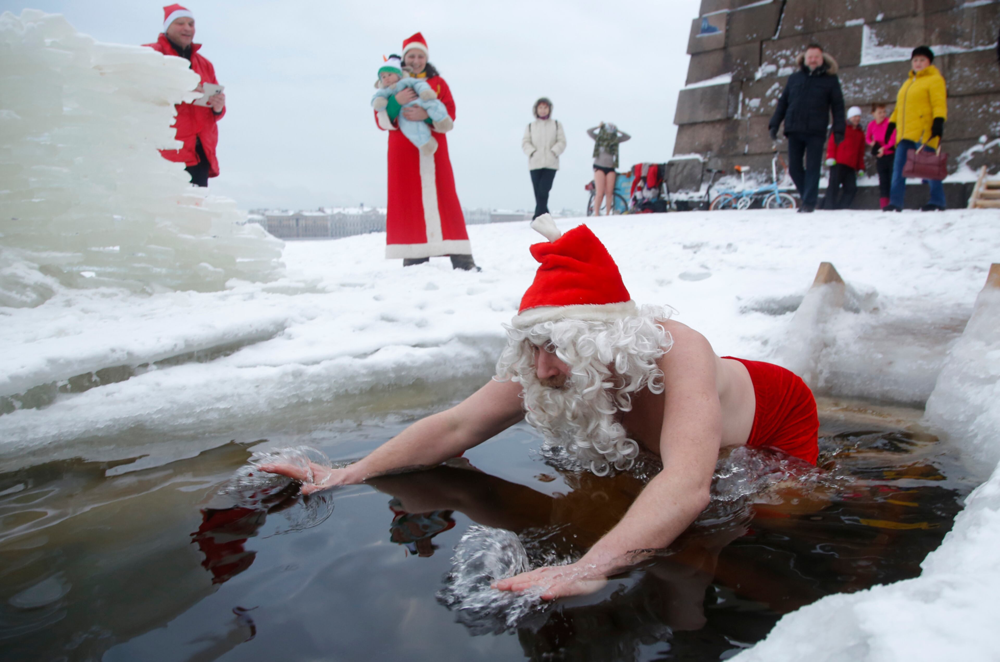 A man wearing a Ded Moroz (also known as Santa Claus, or Grandfather Frost) costume swims in icy water in the Neva River, as he an his friends celebrate Old New Year in St.Petersburg, Russia, Saturday, Jan. 14, 2017. Russian people celebrate so-called Old New Year, which comes on Jan. 14 under the Julian calendar formerly used by Russia and still observed by its Orthodox Church. For most Russians the Old New Year is just a way to prolong the New Year's celebrations. (AP Photo/Dmitri Lovetsky)