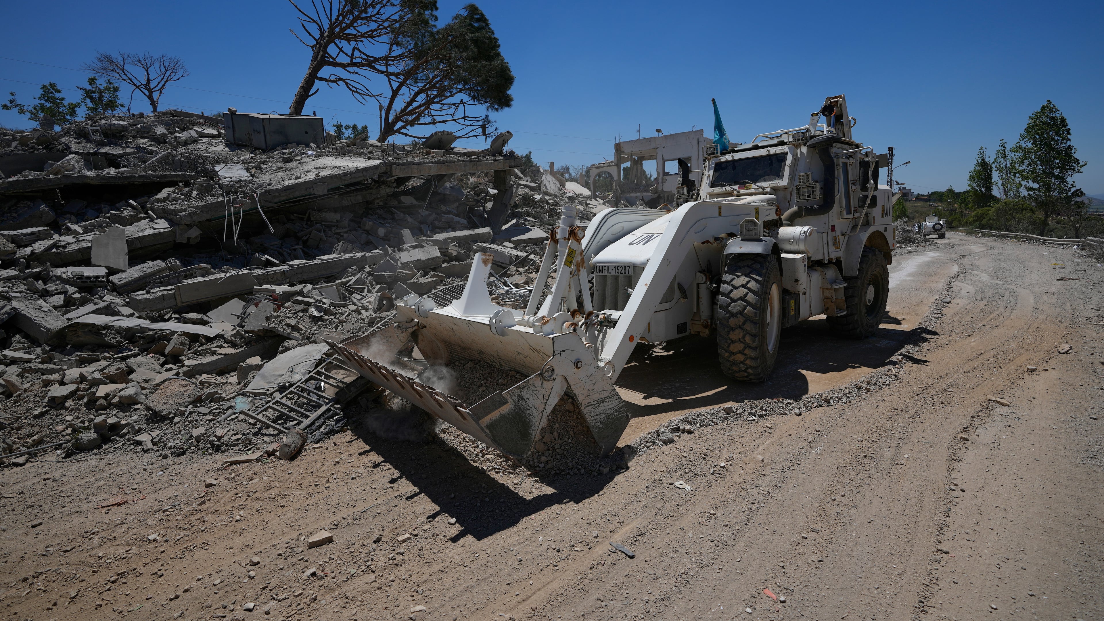 A bulldozer for the Spanish U.N peacekeeper opens a road in front of a house that was destroyed in the recent clashes between Hezbollah fighters and Israeli troops in Dibbine village, southeast Lebanon, Friday, June 5, 2026, a day after Israeli forces withdrew. (AP Photo/Hussein Malla)