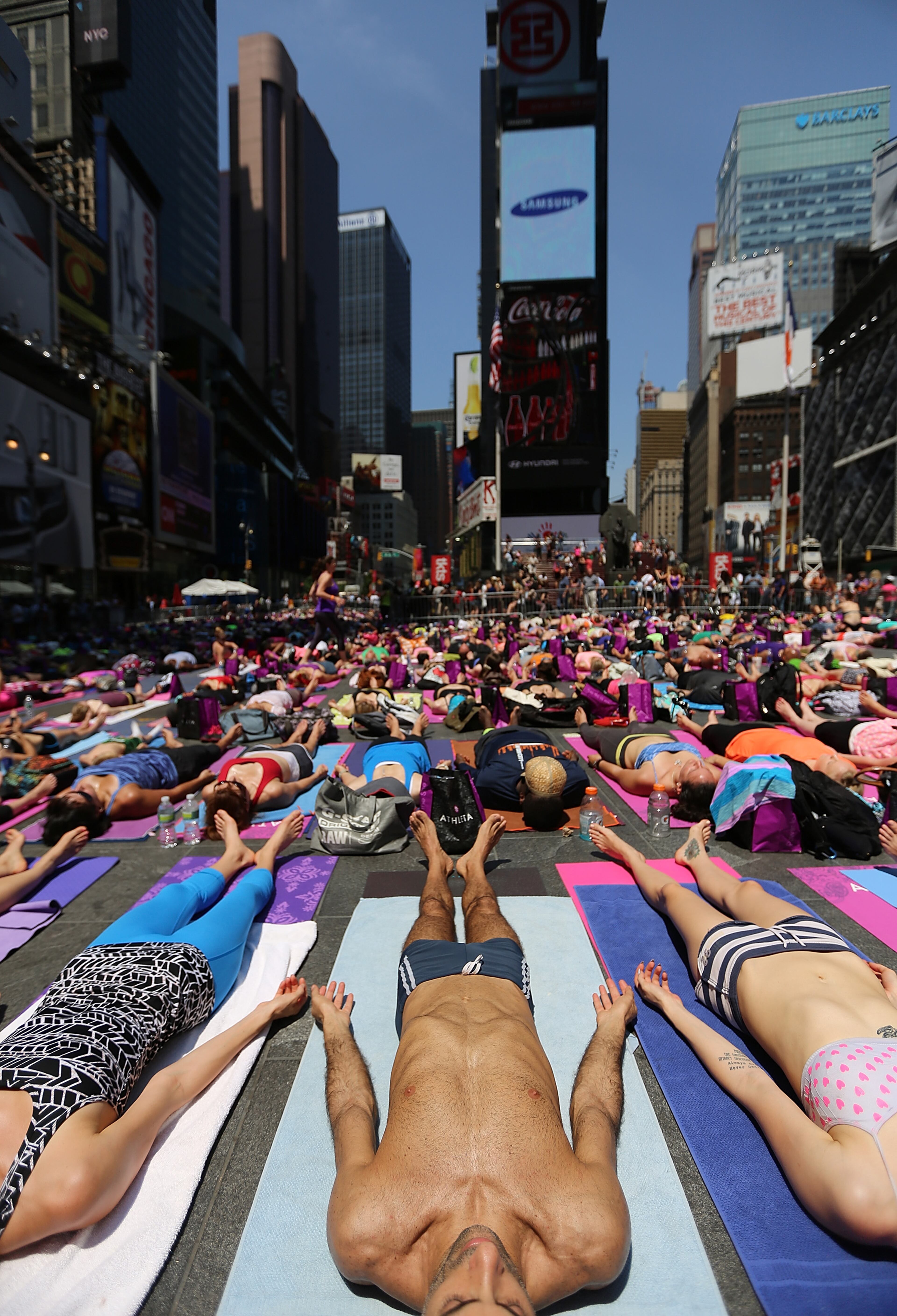 NEW YORK, NY - JUNE 21: Simeone Scaramozzino (C) and other enthusiasts perform yoga in Times Square during an event marking the summer solstice on June 21, 2013 in New York City. Thousands of yogis will attend the free day-long event in Manhattan on the longest day of the year. (Photo by Mario Tama/Getty Images)