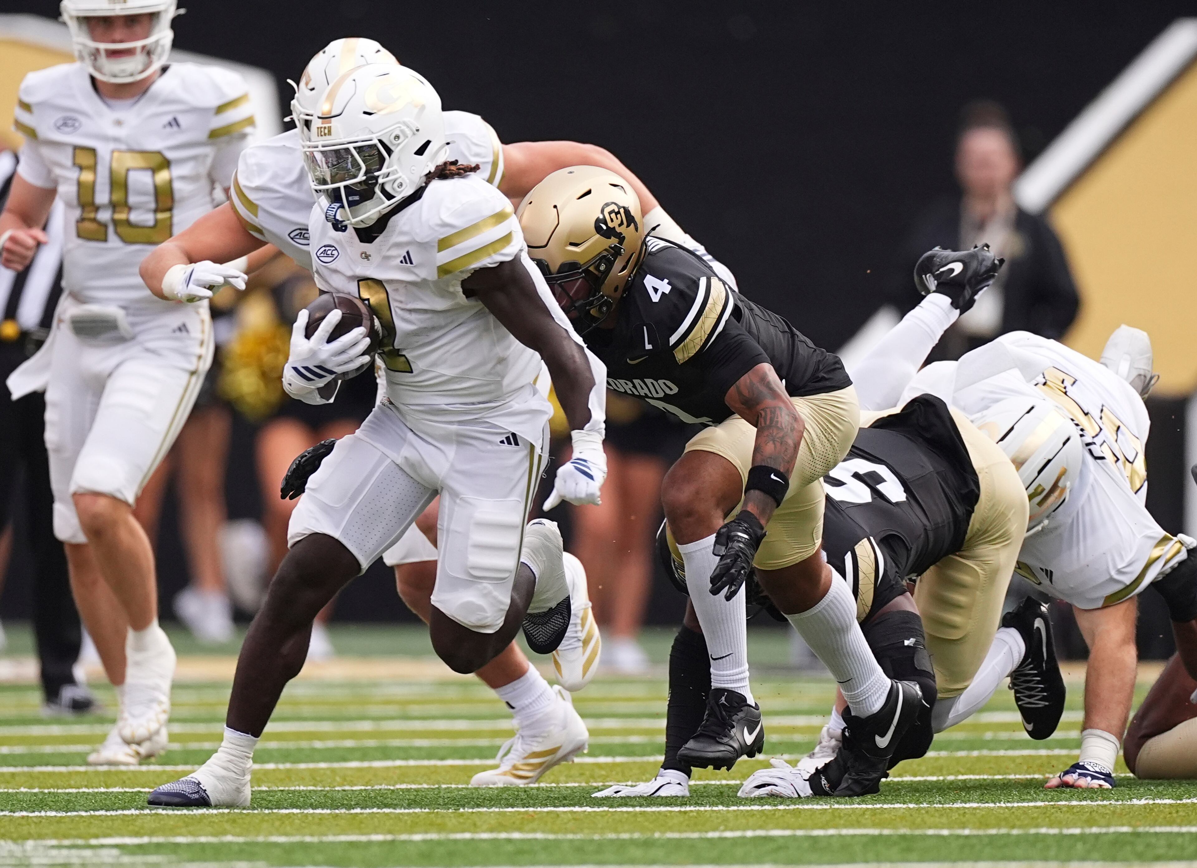 Georgia Tech running back Jamal Haynes (left) runs for a long gain past Colorado cornerback Preston Hodge (center) and linebacker Reginald Hughes during the first half on Friday, Aug. 29, 2025, in Boulder, Colo. (David Zalubowski/AP)