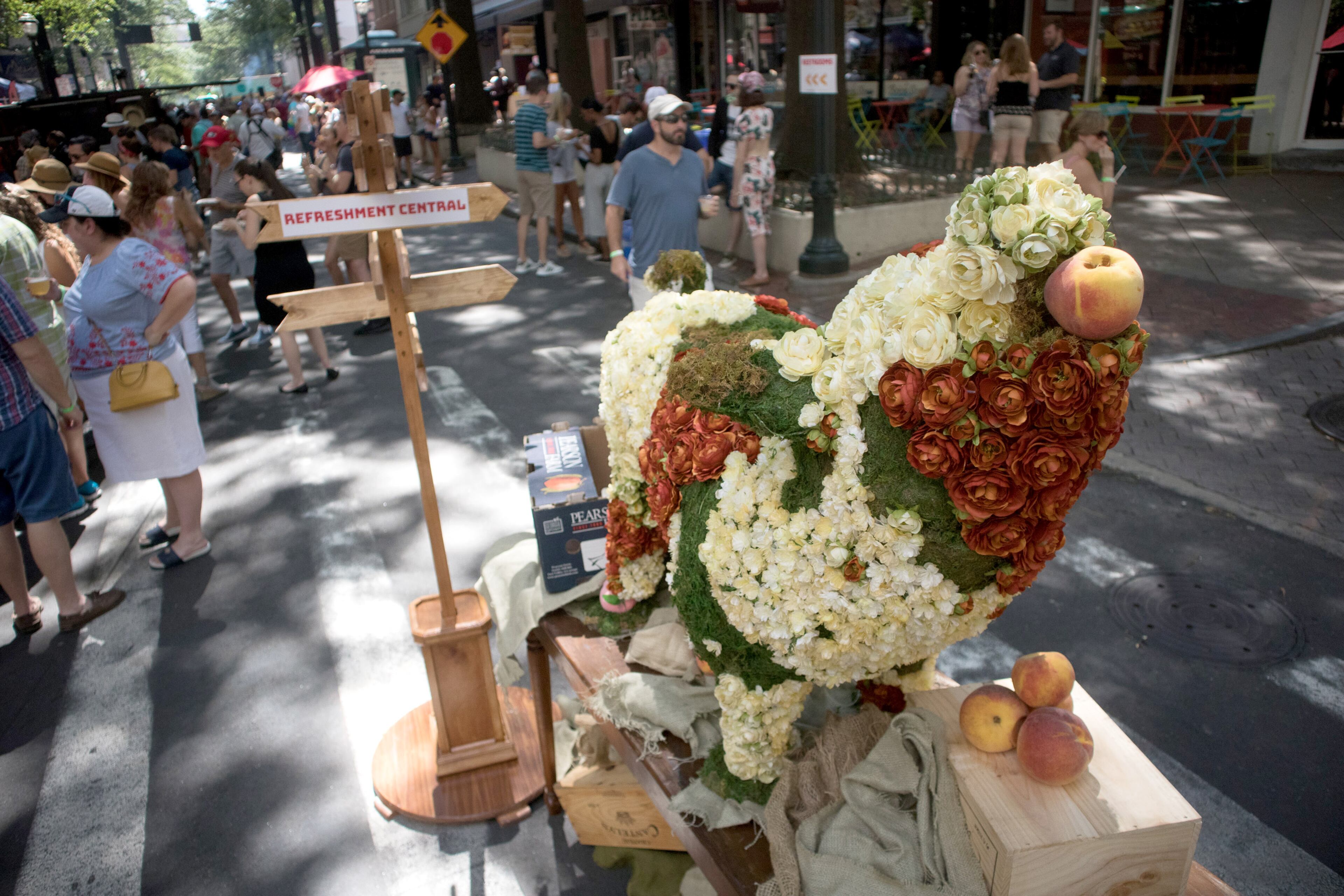 A sculpture of a pig made of flowers with a peach in its mouth stands on Broad Street during the PeachFest in Atlanta Ga Sunday, July 29, 2018. PeachFest a non-profit festival, returned to downtown Atlanta for its second year. STEVE SCHAEFER / SPECIAL TO THE AJC