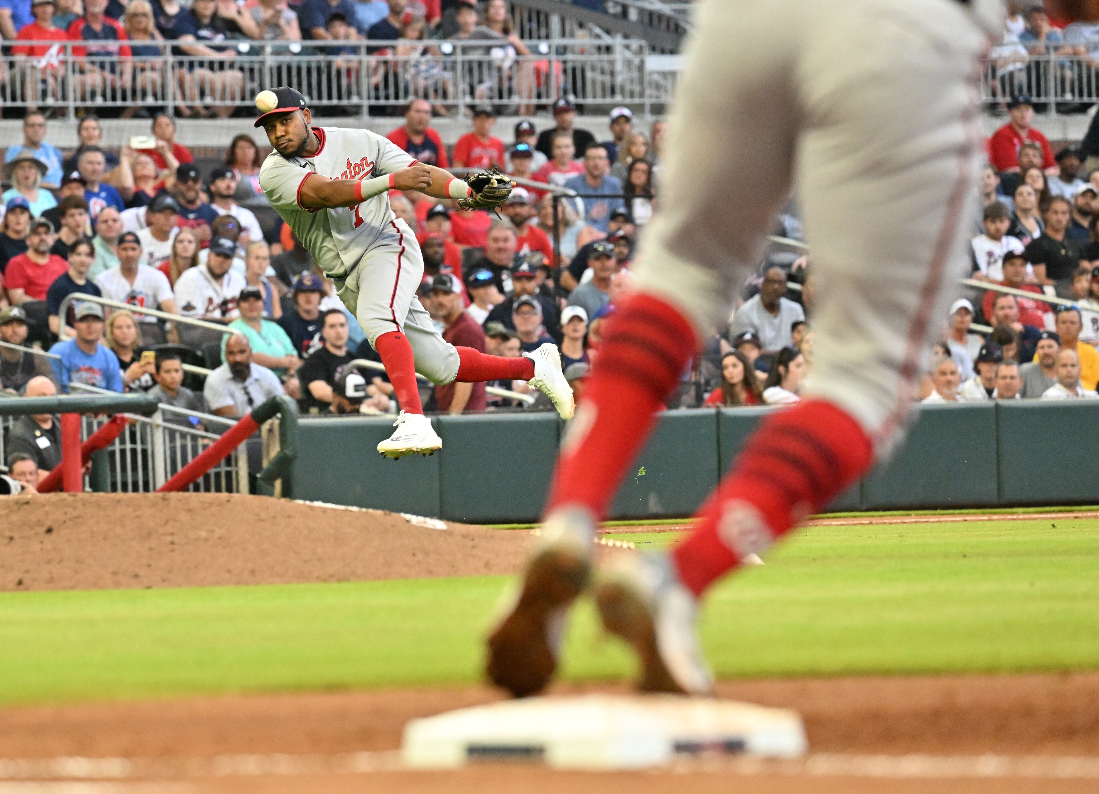 Washington Nationals' third baseman Maikel Franco (7) throws to the first base but can’t put out Atlanta Braves' shortstop Dansby Swanson (7) in the second inning at Truist Park on Friday, July 8, 2022. (Hyosub Shin / Hyosub.Shin@ajc.com)