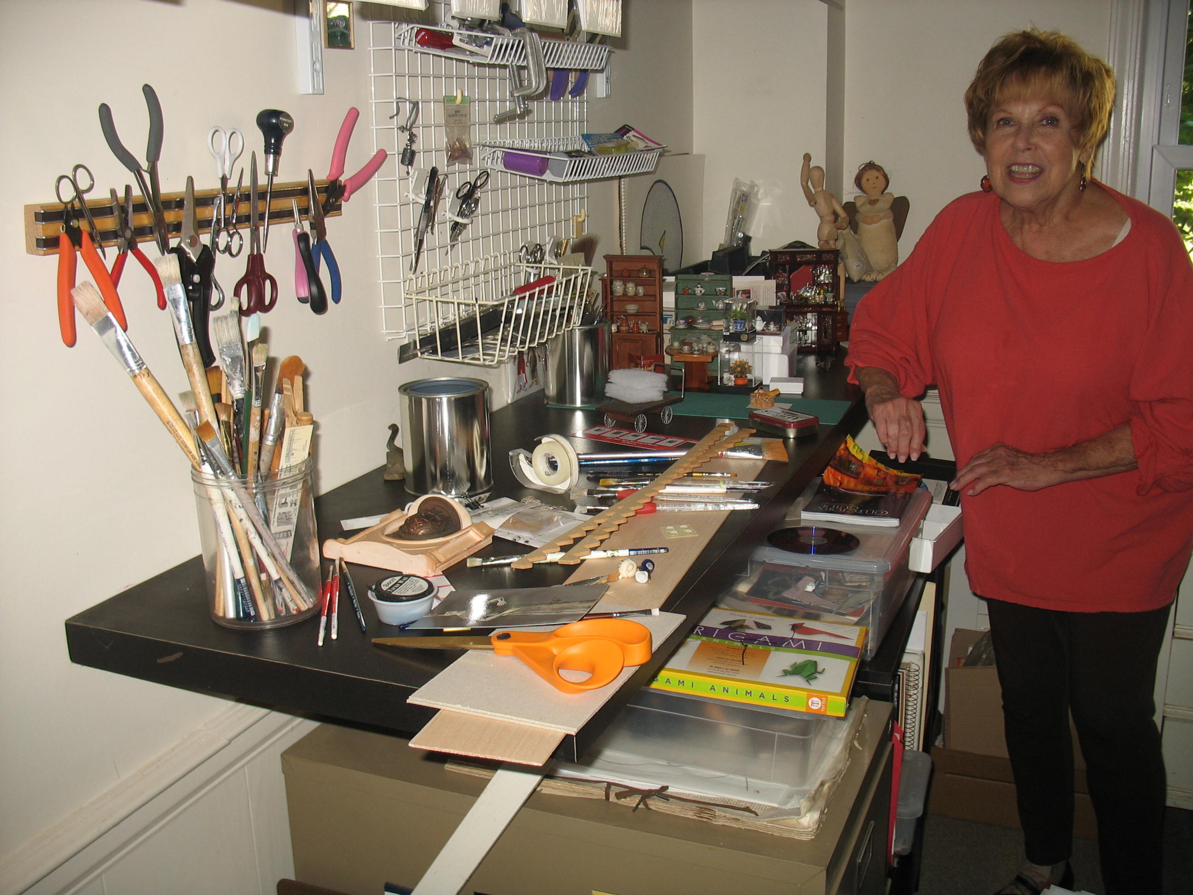 Clarice Elder in the room of her Dunwoody home where she works on her clever and whimsical "room boxes." The author of several books on minature needlepoint, Elder has even made a miniature braided rug for one of her "rooms."