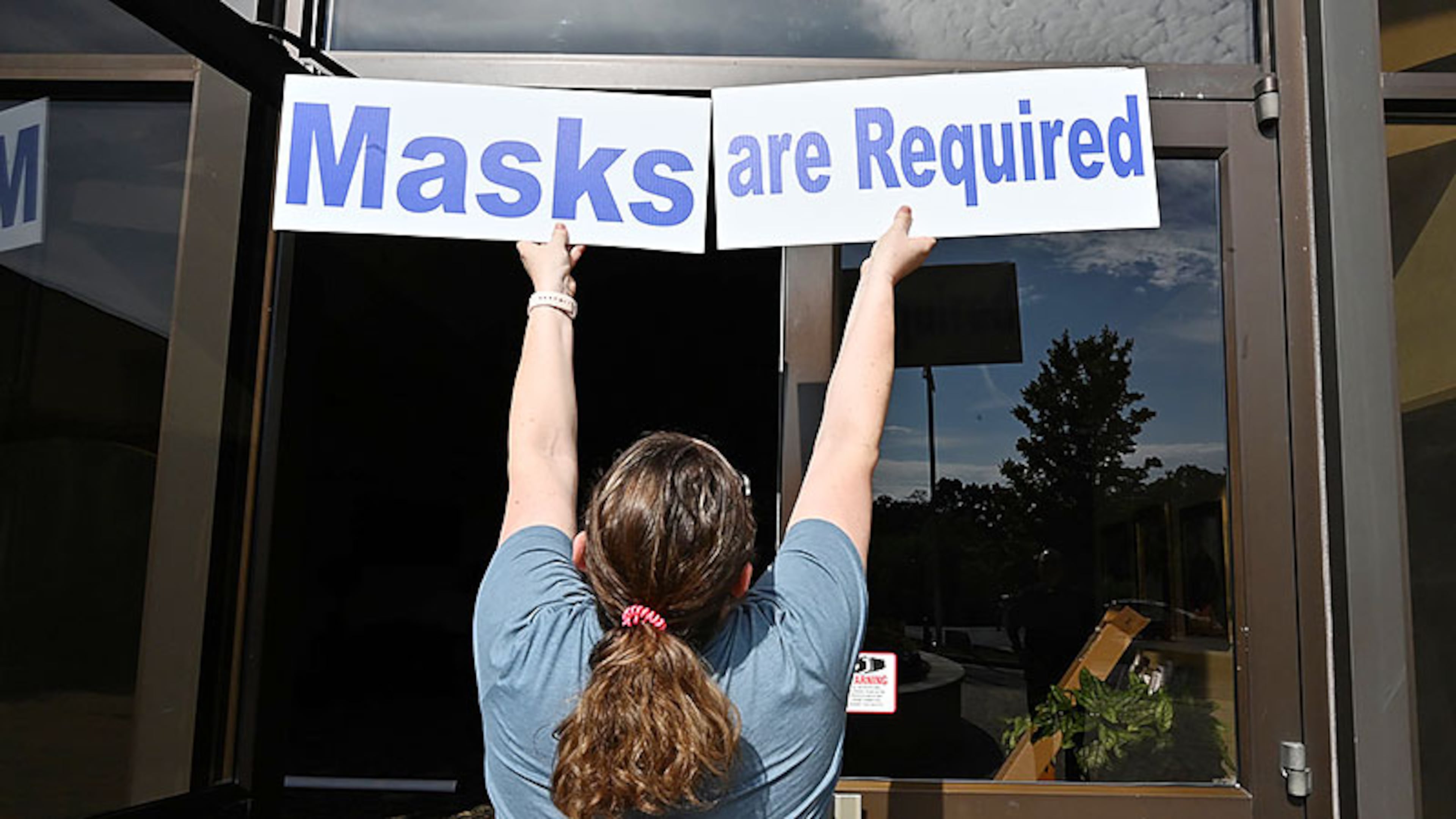 Mary Beth McKenna, director of religious education, checks a position for signs ahead of reopening of daily in-person Mass at St. Benedict Catholic Church in this May 2020 file photo.