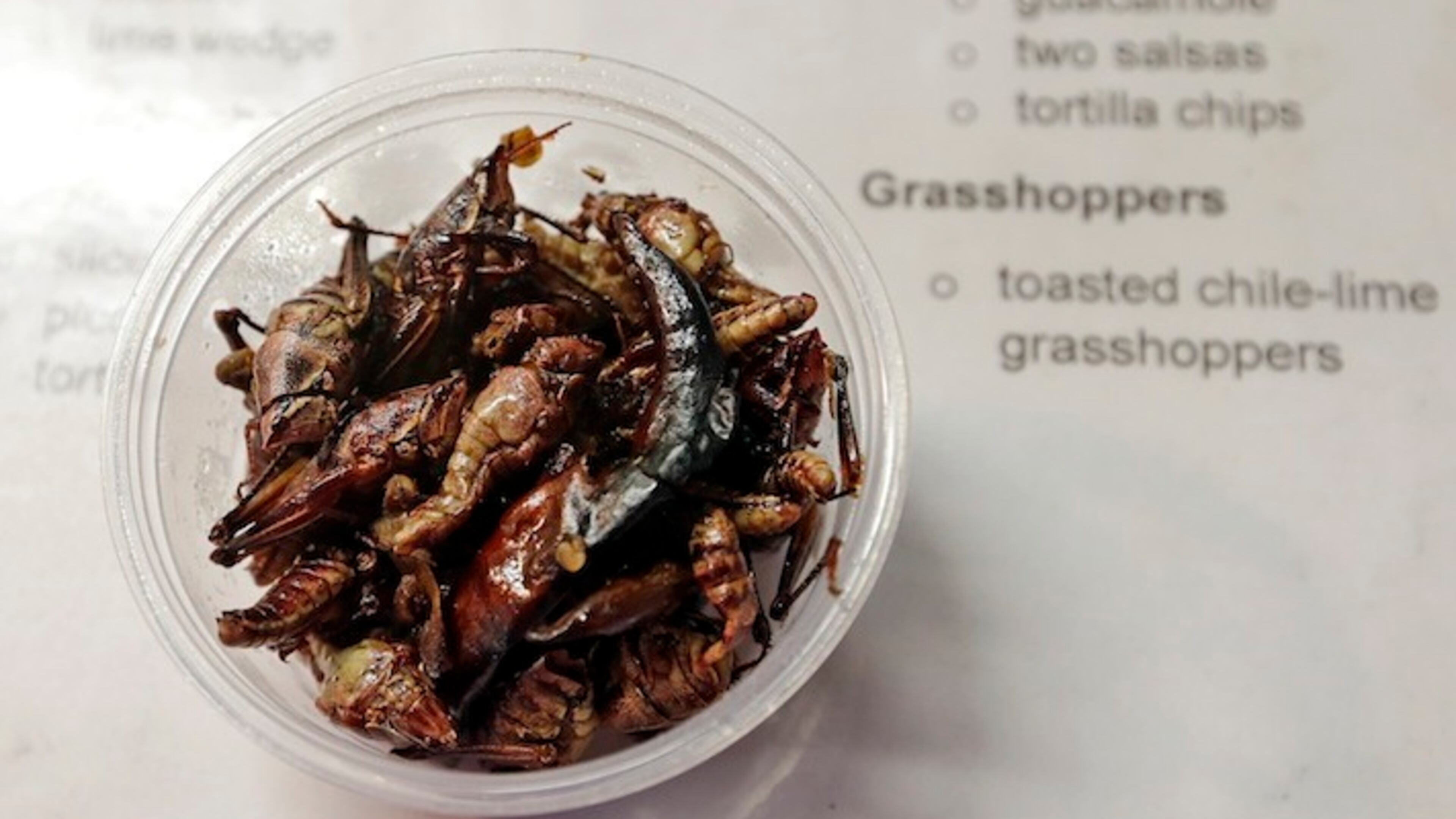 Toasted chile-lime grasshoppers are displayed on a menu at a baseball game between the Seattle Mariners and the Los Angeles Angels Tuesday, May 2, 2017, in Seattle. (AP Photo/Elaine Thompson)