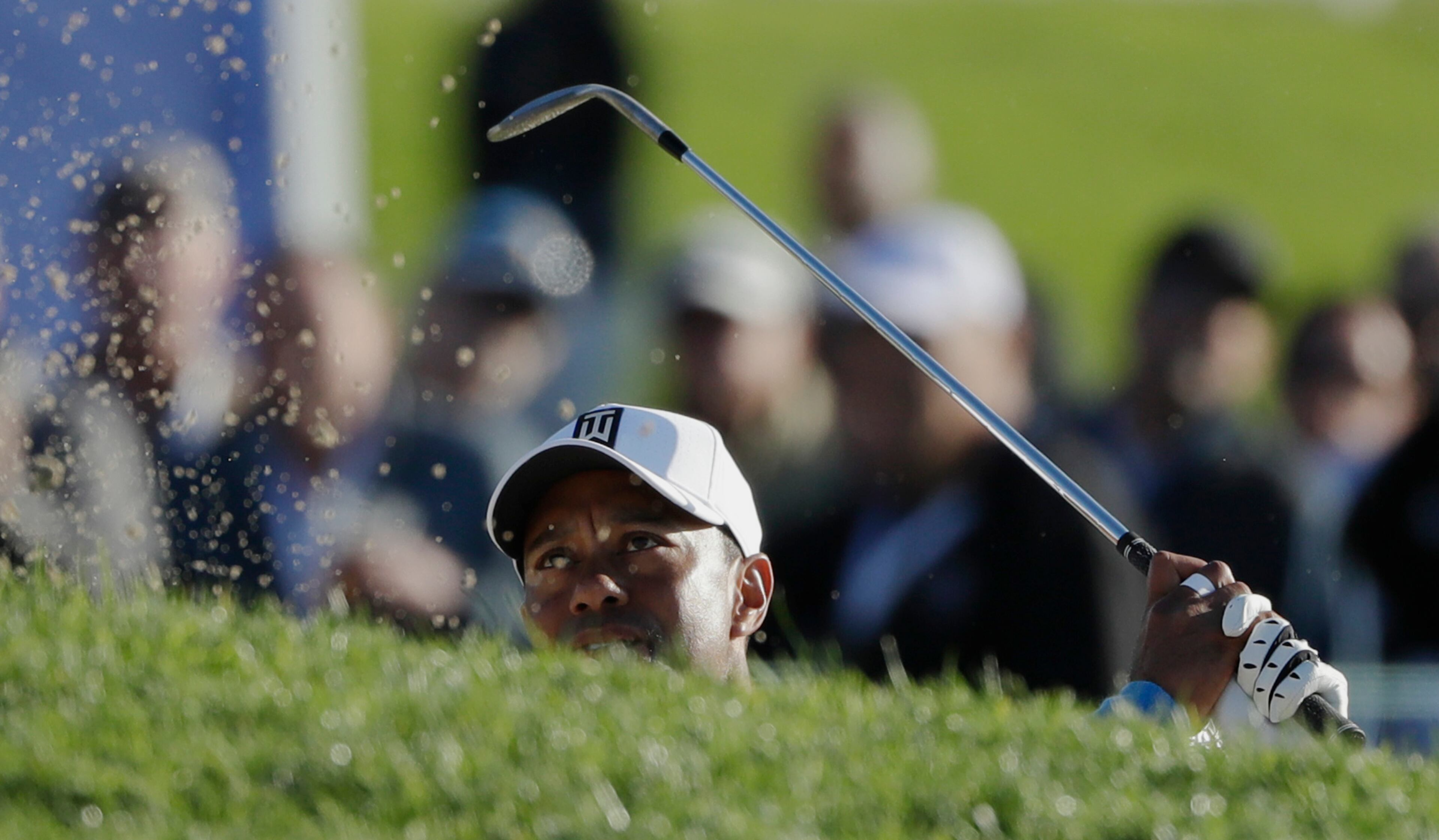 Tiger Woods hits out of a bunker on the 17th hole of the south course during the first round of the Farmers Insurance Open golf tournament Thursday, Jan. 26, 2017, at Torrey Pines Golf Course in San Diego. (AP Photo/Gregory Bull)