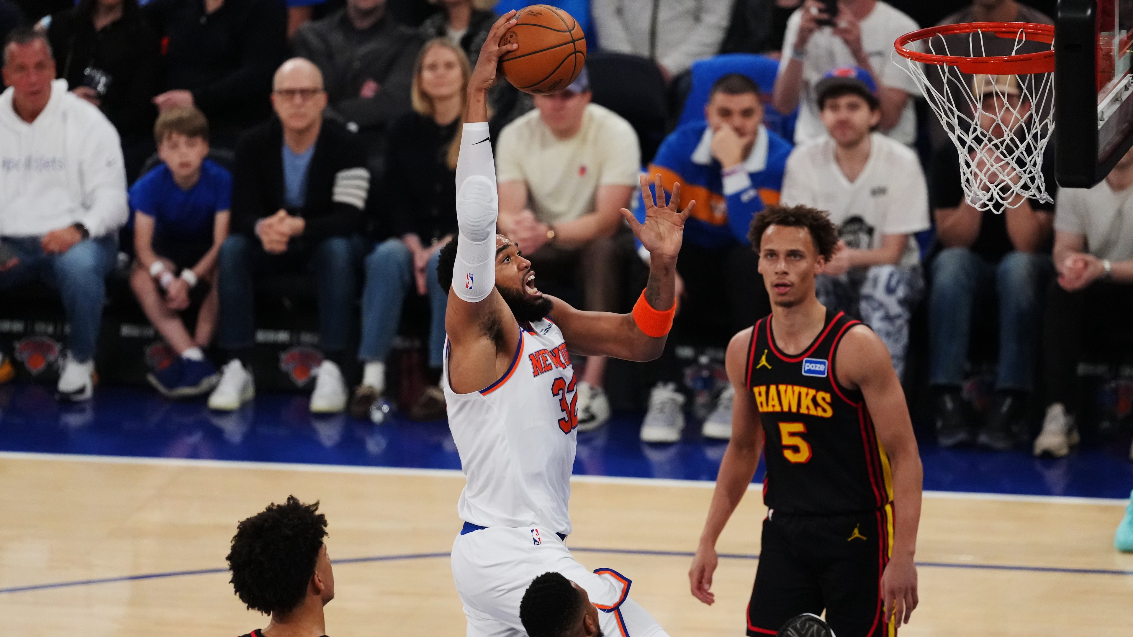 New York Knicks' Karl-Anthony Towns (32) drives past Atlanta Hawks' Dyson Daniels (5) during the first half in Game 1 of a first-round NBA playoffs basketball series, Saturday, April 18, 2026, in New York. (AP Photo/Frank Franklin II)