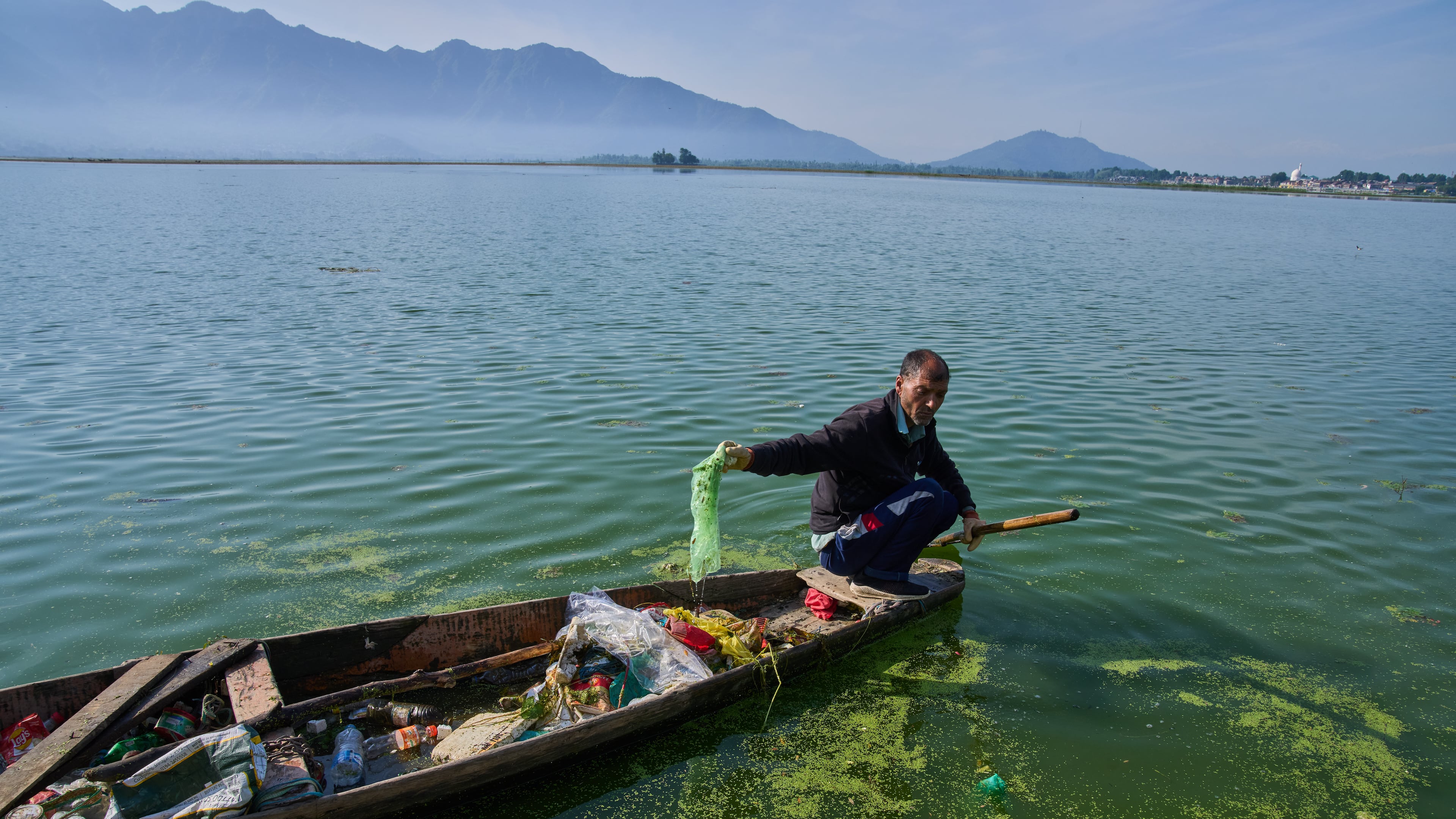 Mohammad Amin, a Kashmiri laborer employed by a nonprofit organization that collects garbage floating on Dal Lake, works on the outskirts of Srinagar, Indian controlled Kashmir, Monday, May 4, 2026. (AP Photo/Dar Yasin)