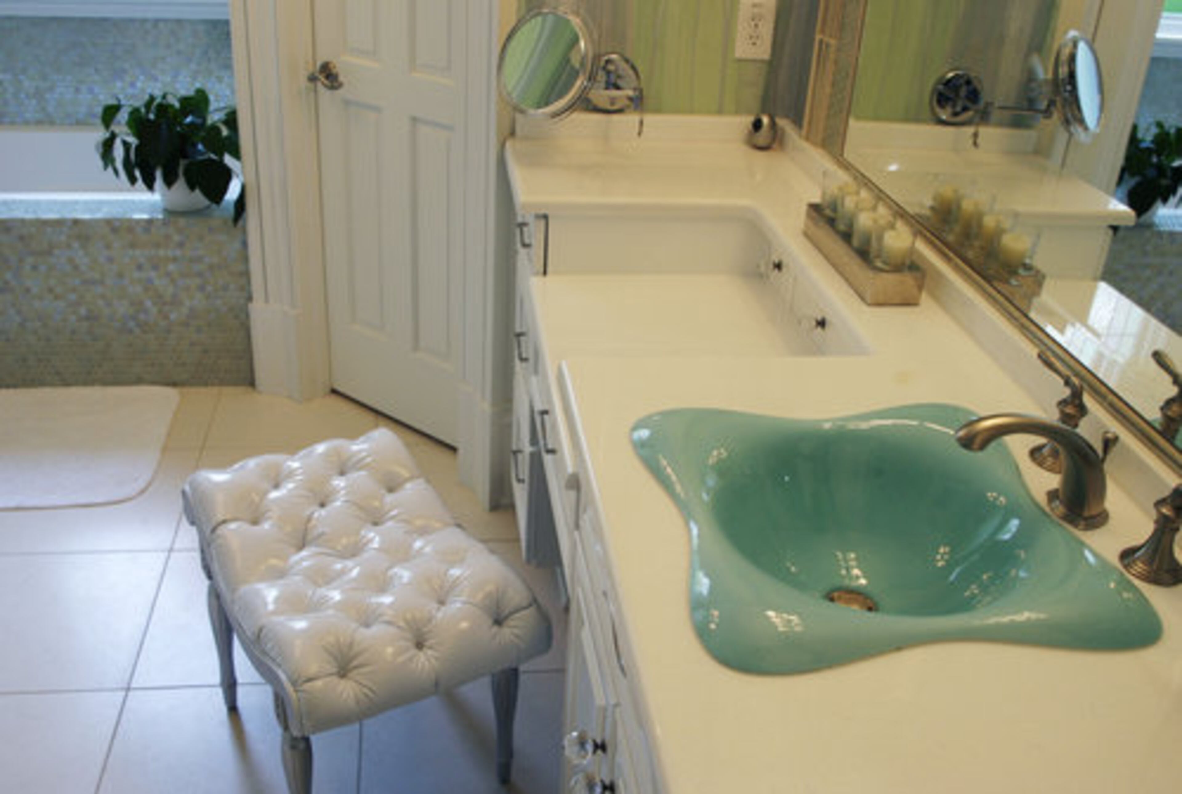 The spa feeling flows into Diana's bathroom with iridescent tiles and an organic-shaped sink in aqua.