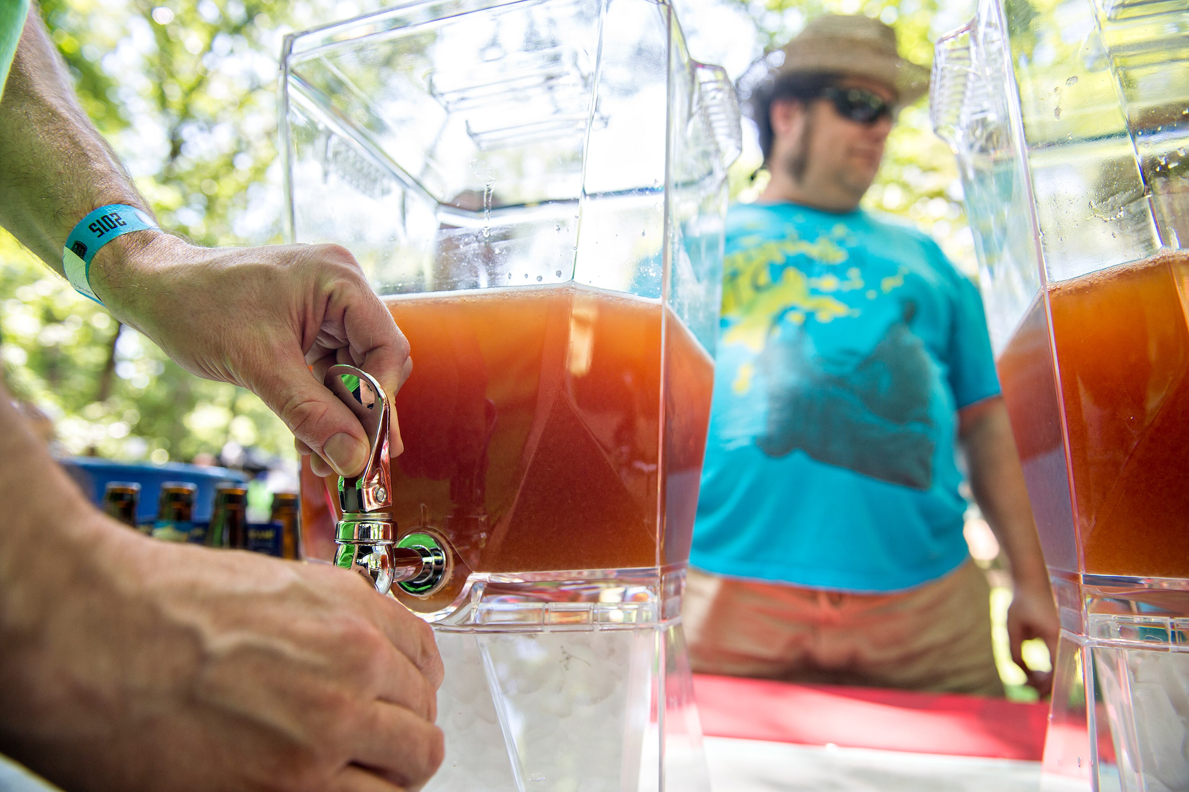 Dan Hourigan (hands) pours a mixture of Fourth Ward Distillery vodka, SweetWater Blue, lemon and bitters for Karl Harden during the East Atlanta Beer Fest at Brownwood Park on Saturday, May 16, 2015. Thousands of people attended the 12th annual festival which featured 175 craft beers. JONATHAN PHILLIPS / SPECIAL