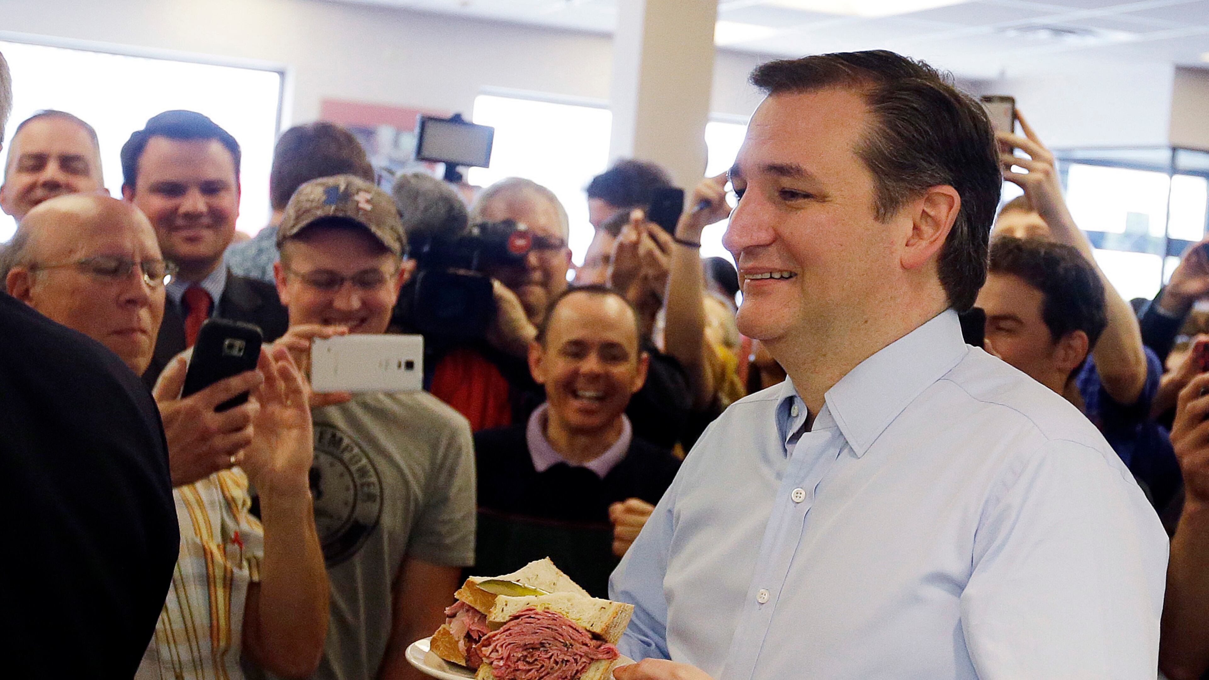FILE - In this April 21, 2016 file photo, Republican presidential candidate, Sen. Ted Cruz, R-Texas, holds his sandwich during a campaign stop at Shapiro's Delicatessen, in Indianapolis. (AP Photo/Darron Cummings, File)