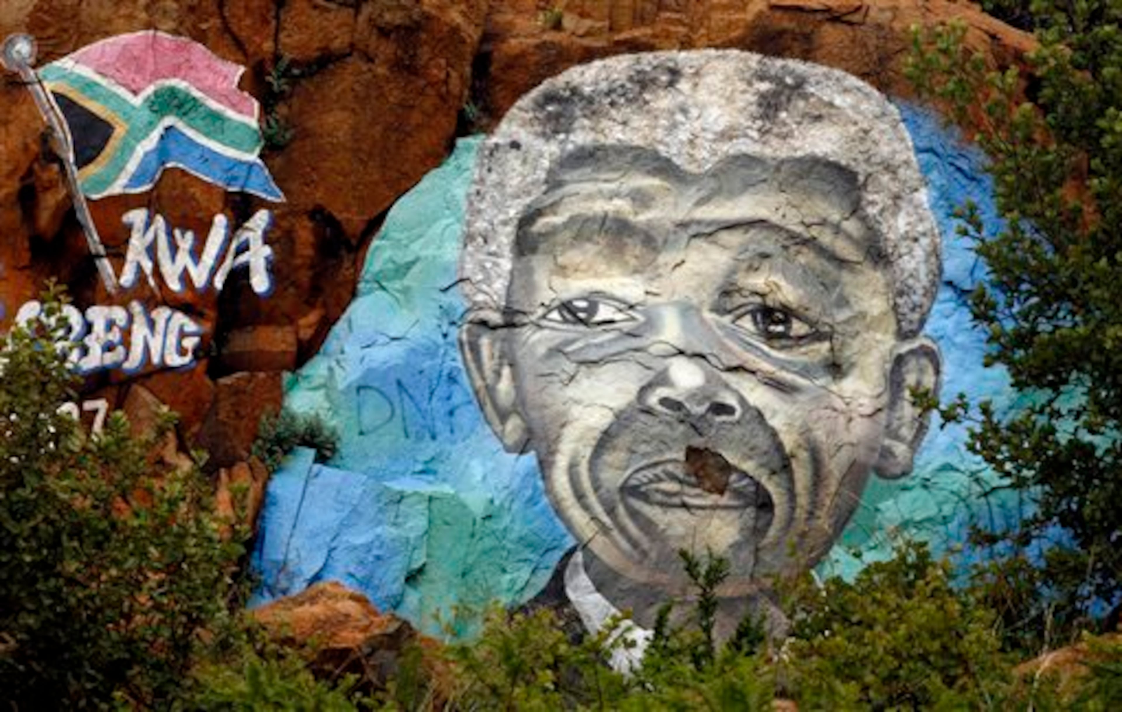 FILE - This Dec. 12, 2012 file photo shows a mural depicting former President Nelson Mandela on a hill in Soweto, South Africa. On Thursday, Dec. 5, 2013, Mandela died at the age of 95. (AP Photo/Themba Hadebe, File)