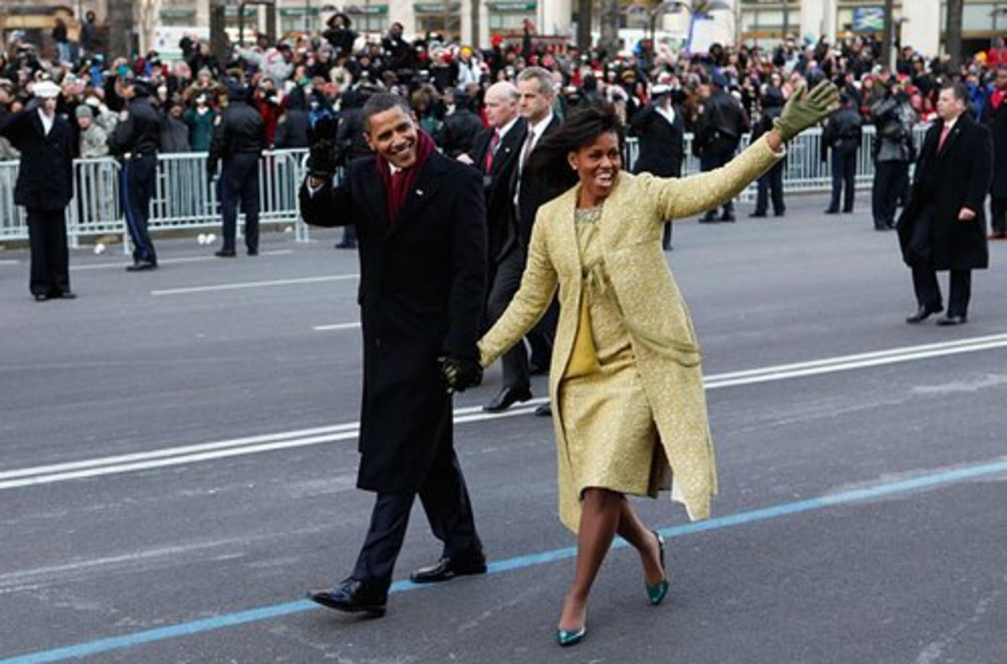 Obama and first lady Michelle Obama wave to the cheering crowd while walking part of the inaugural parade route along Pennsylvania Avenue.