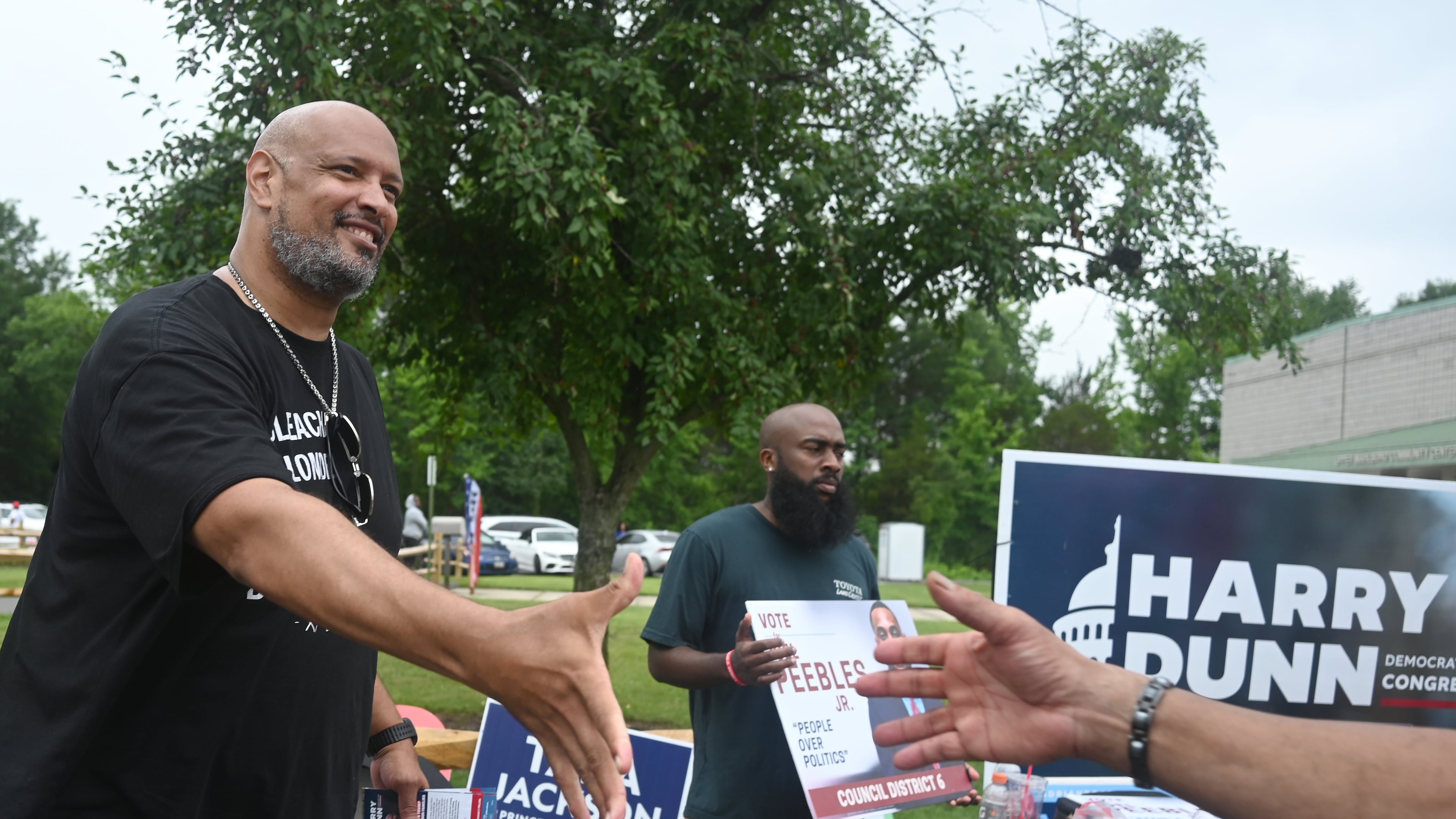 Harry Dunn, former U.S. Capitol police officer and candidate for U.S. Congress greets a voter Tuesday, June 23, 2026, in Upper Marlboro, Md. (AP Photo/Gail Burton)