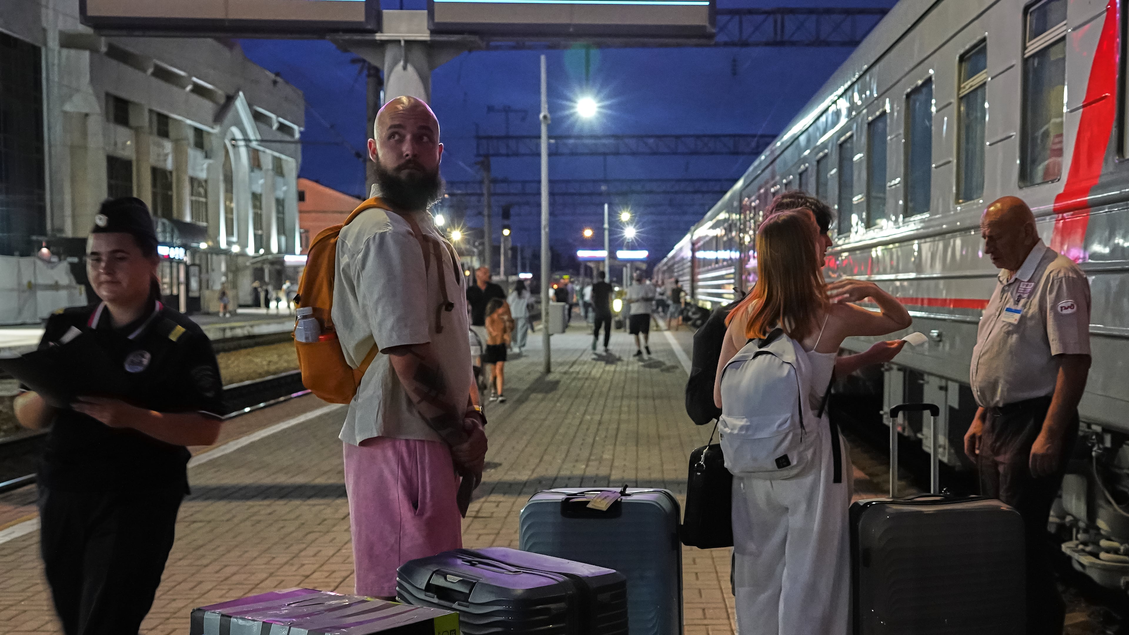 A 28-year-old digital content marketer who decided to leave Russia stands near his packed belongings at the railway station in Krasnodar, Russia, on Saturday, Aug. 29, 2026. He asked not to be identified because of security concerns. (AP Photo)