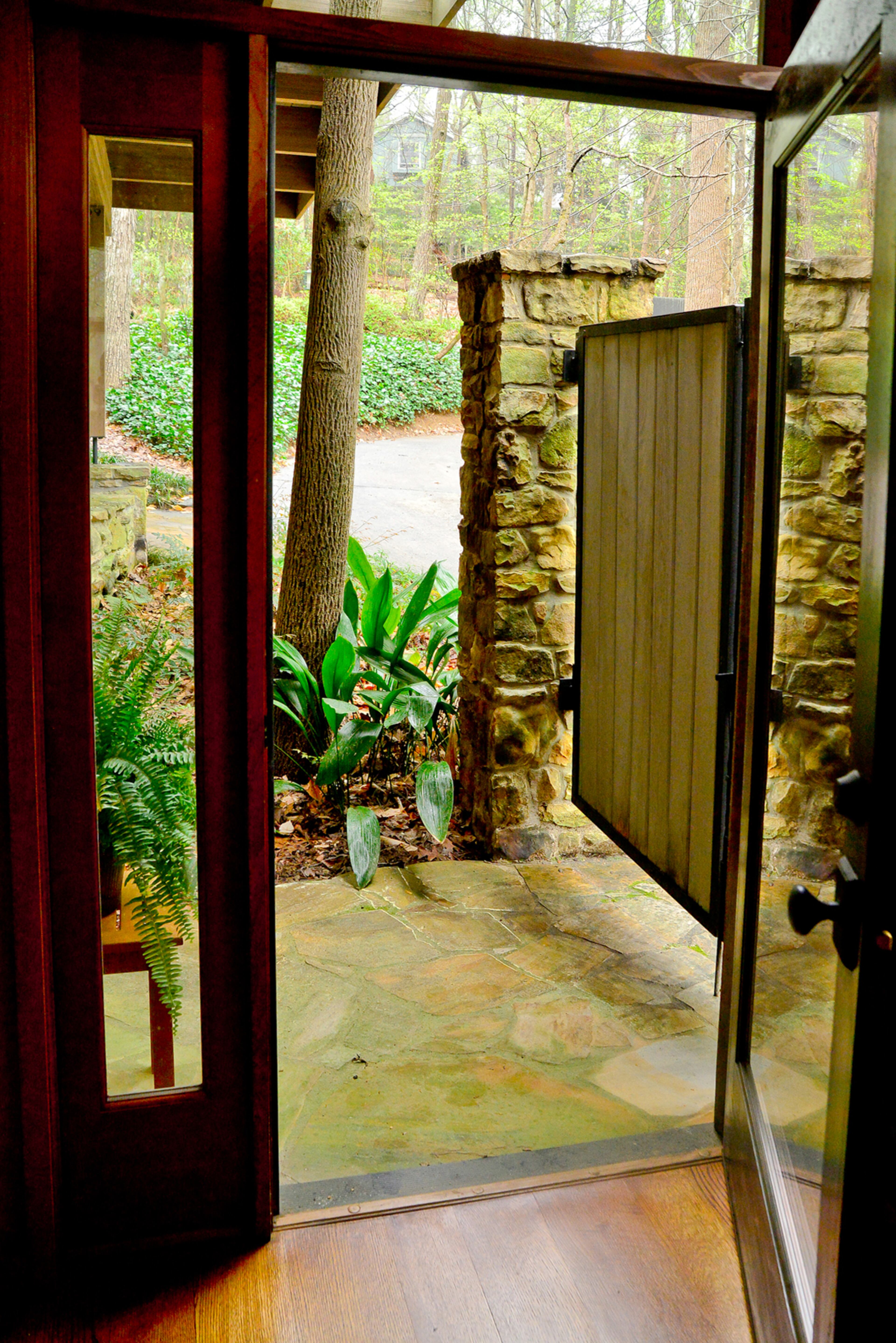 A ramp made from the same stone as the rest of the home leads to the side addition in Mary Emma and Dan McConaughey's Druid Hills home. The addition by their son, Warner McConaughey of HammerSmith, is aging-in-place friendly and was designed to fit with the existing rustic character.