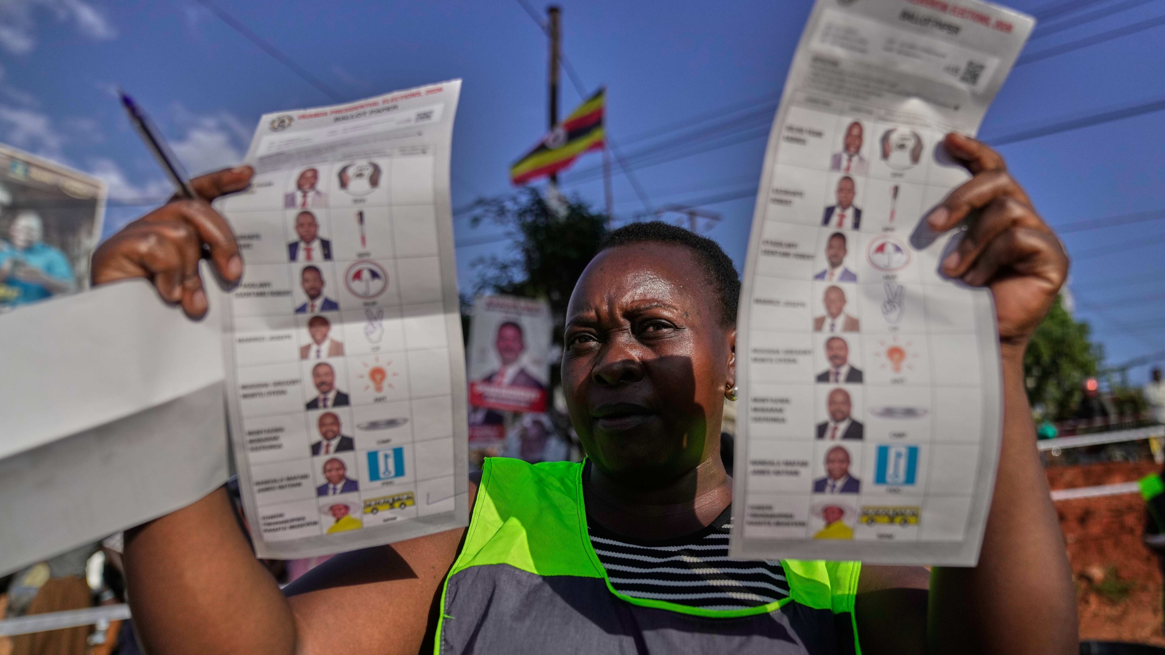 An election official holds up unmarked ballots during the vote count after polls closed for the presidential election, at a polling center in Kampala, Uganda, Thursday, Jan. 15, 2026. (AP Photo/Brian Inganga)