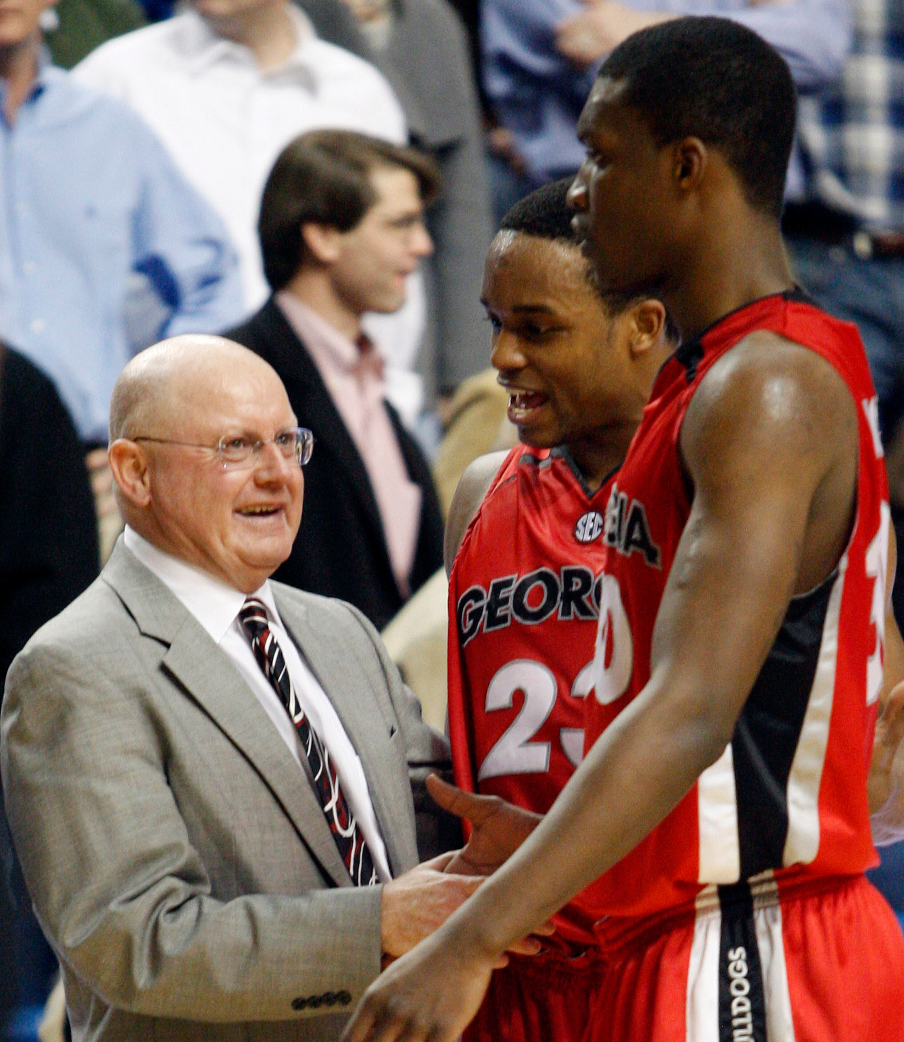 Georgia coach Pete Herrmann, left, congratulates Corey Butler, center, and Terrance Woodbury at the end of Georgia's 90-85 NCAA college basketball victory over Kentucky at Rupp Arena in Lexington, Ky., on Wednesday, March 4, 2009. Woodbury led all scorers with 30 while Butler scored 13. (AP Photo/James Crisp)