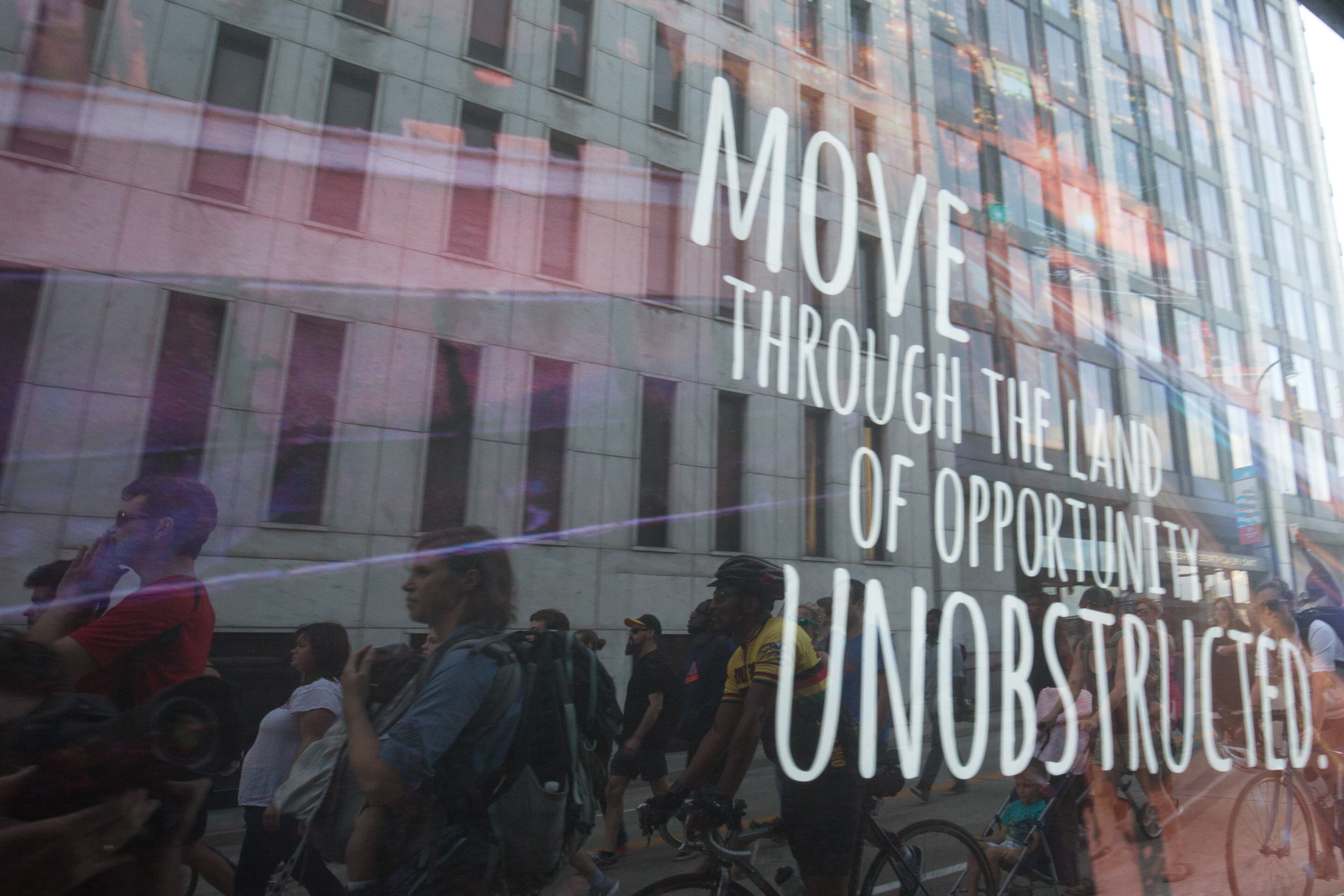 Demonstrators are reflected in a sign as they march from Underground Atlanta to Piedmont Park, Thursday, July 7, 2016, in Atlanta. Demonstrators gathered in response to the death of Alton Sterling, 37, who was killed by Baton Rouge police outside of a convenience store where he was selling CDs and Philando Castile, who was shot and killed when Minnesota police stopped him for a traffic violation on Wednesday evening. BRANDEN CAMP/SPECIAL