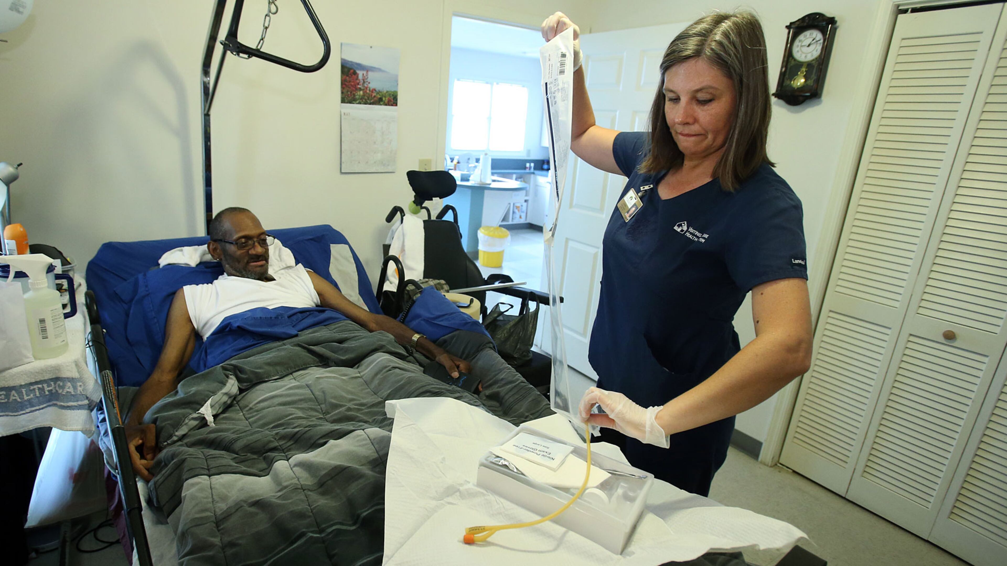 Lynn Adams cares for patient Willie Peterson II, who was paralyzed from the waist down by a falling tree in 1998 and needs regular skilled medical attention.