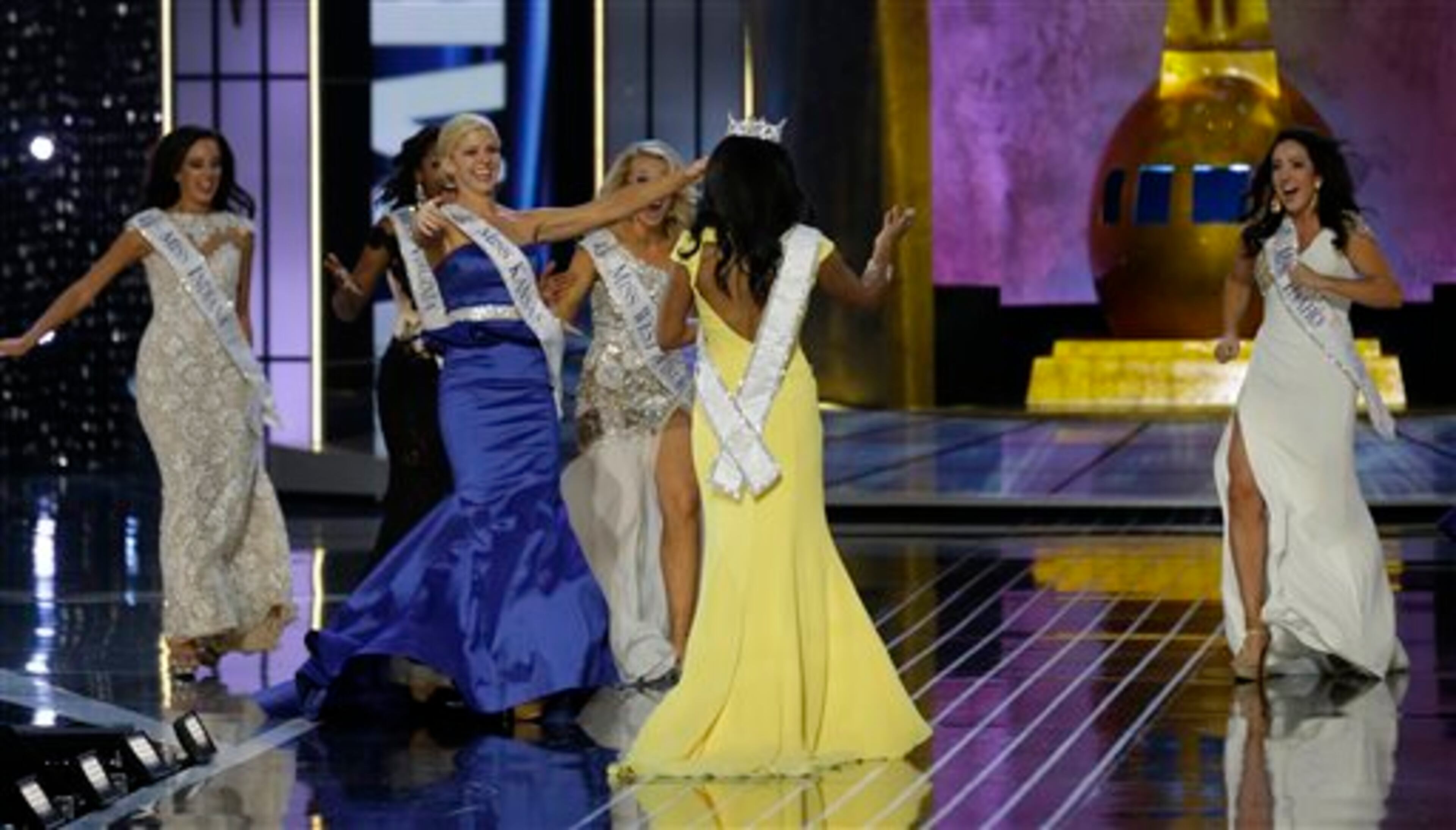 Miss New York Nina Davuluri, center, is approached by contestants after Davuluri was crowned as Miss America 2014, Sunday, Sept. 15, 2013, in Atlantic City, N.J. (AP Photo/Mel Evans)