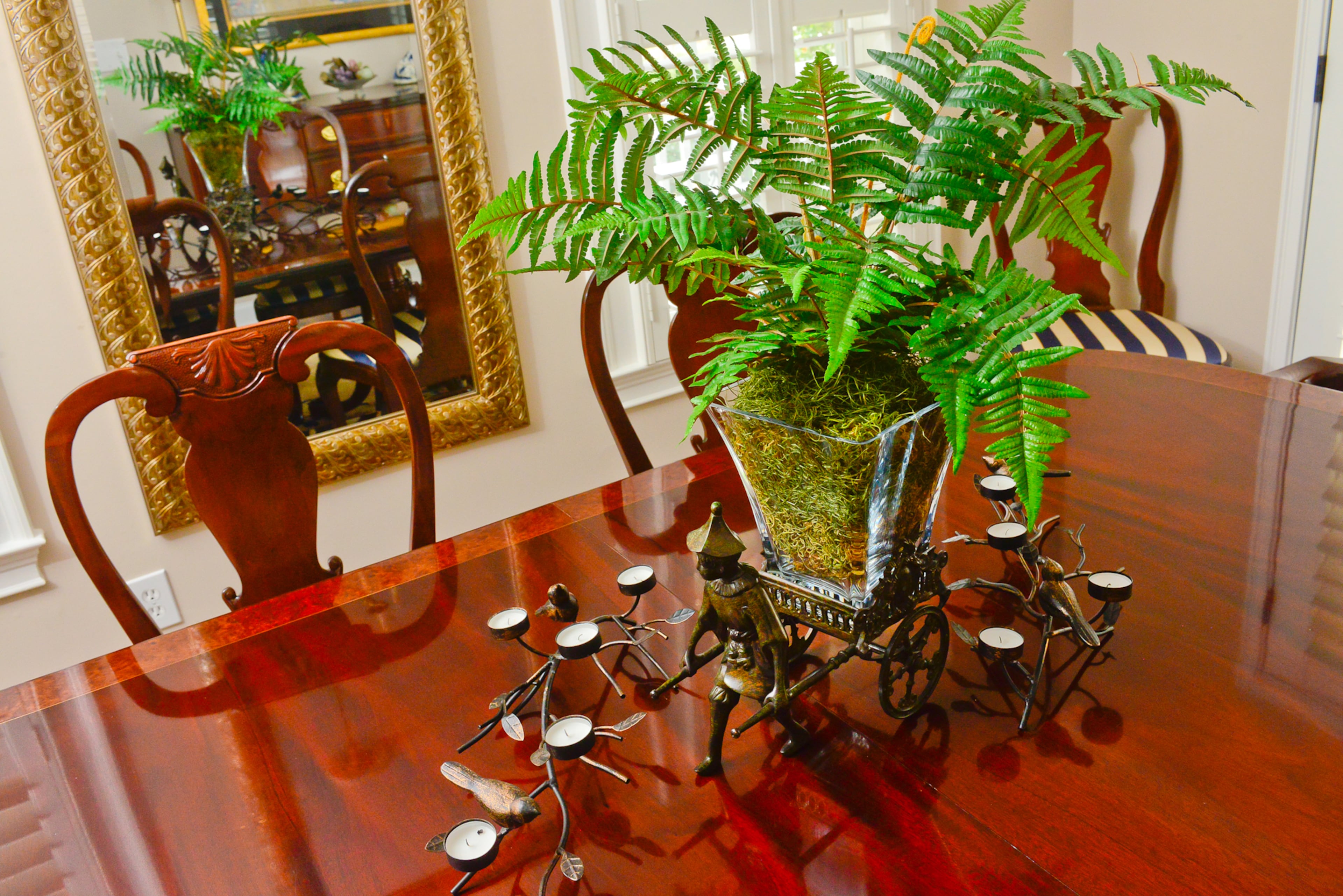 A potted fern adds color and a touch of nature to Linda and Chris Clark's traditional home. Acting as the dining room table centerpiece, the fern sits atop an Oriental pull cart statue that the couple bought years ago. Asian influences can be found throughout the home, in part from items given to the couple by Chris' father, who worked for the United Nations and spent time in China.