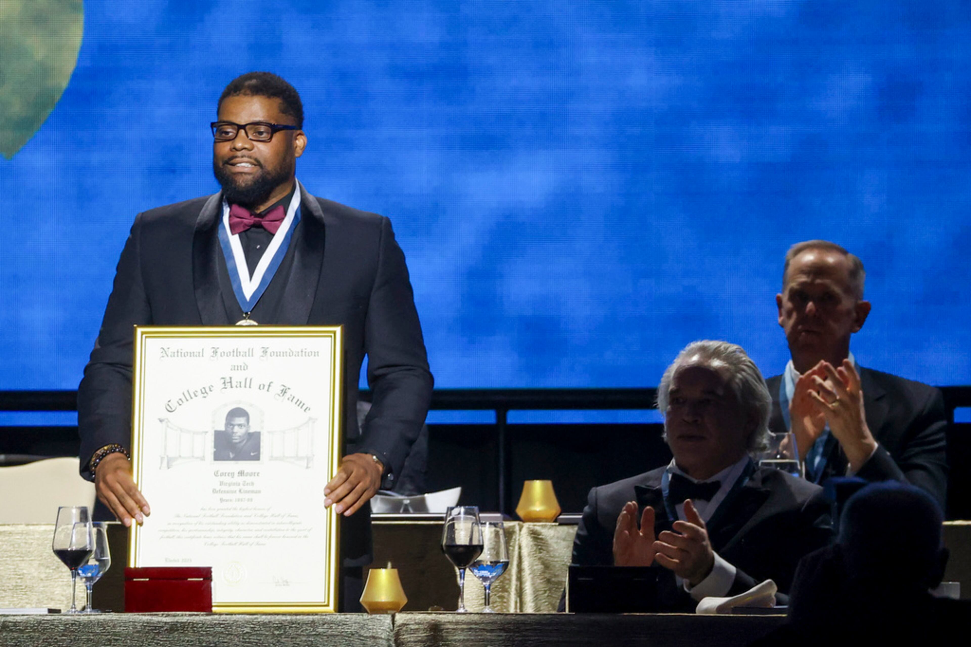 Former Virginia Tech defensive lineman Corey Moore holds up his College Football Hall of Fame Award during the National Football Foundation Awards Dinner, Tuesday, Dec. 5, 2023, in Las Vegas. (AP Photo/Ian Maule)
