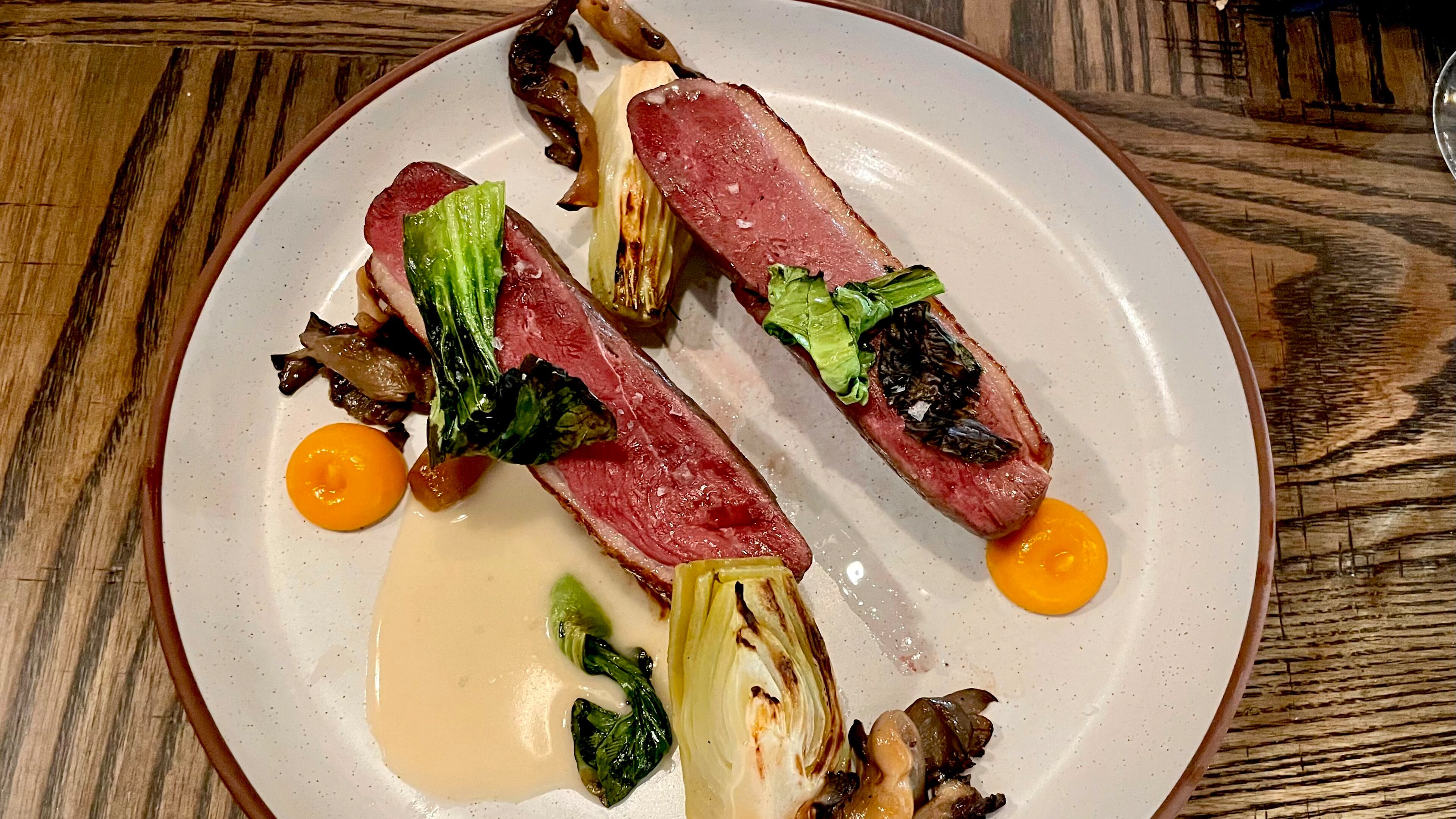 The duck breast at Foundation Social Eatery is served with marinated oyster mushrooms, brined bok choy and kumquat gel. Angela Hansberger for The Atlanta Journal-Constitution