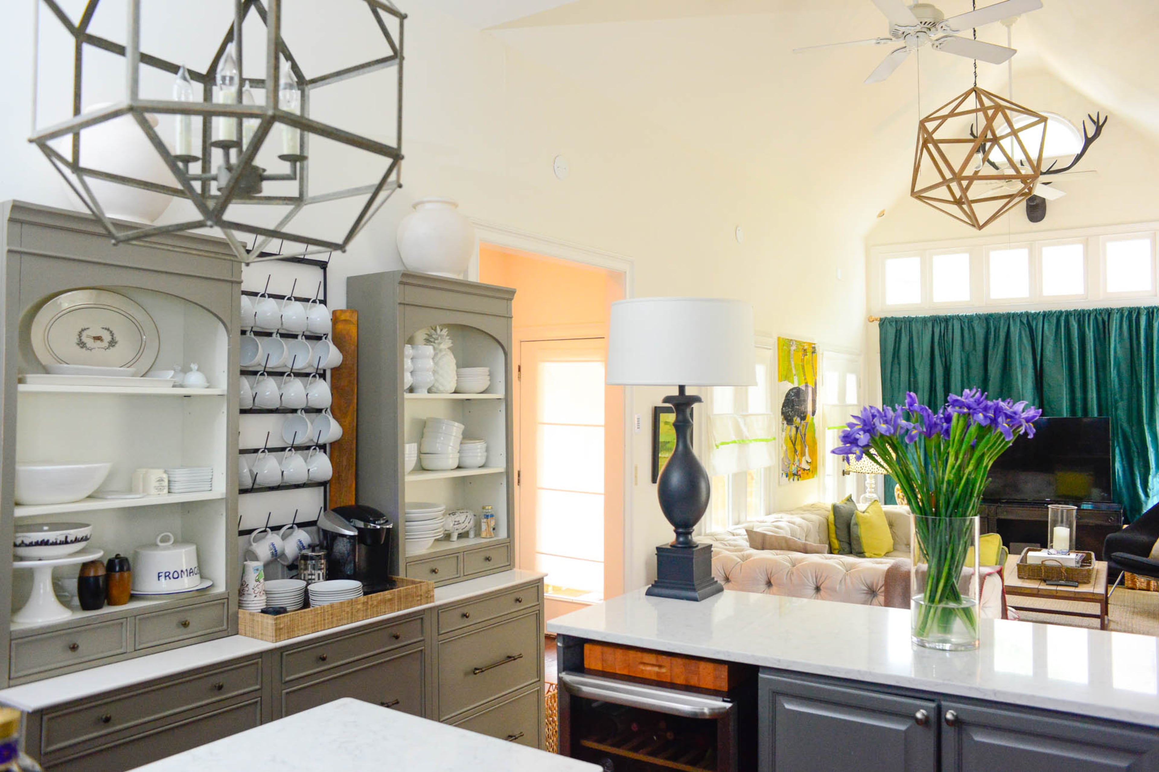 To walk the line between traditional and contemporary, homeowners Brad Resler and David Pippin installed geometric light fixtures from Ballard Designs and topped light gray servers with arched hutches in the kitchen. The large drawers in the Ballard Paulette servers are useful for storing plates and cookware, Resler said.