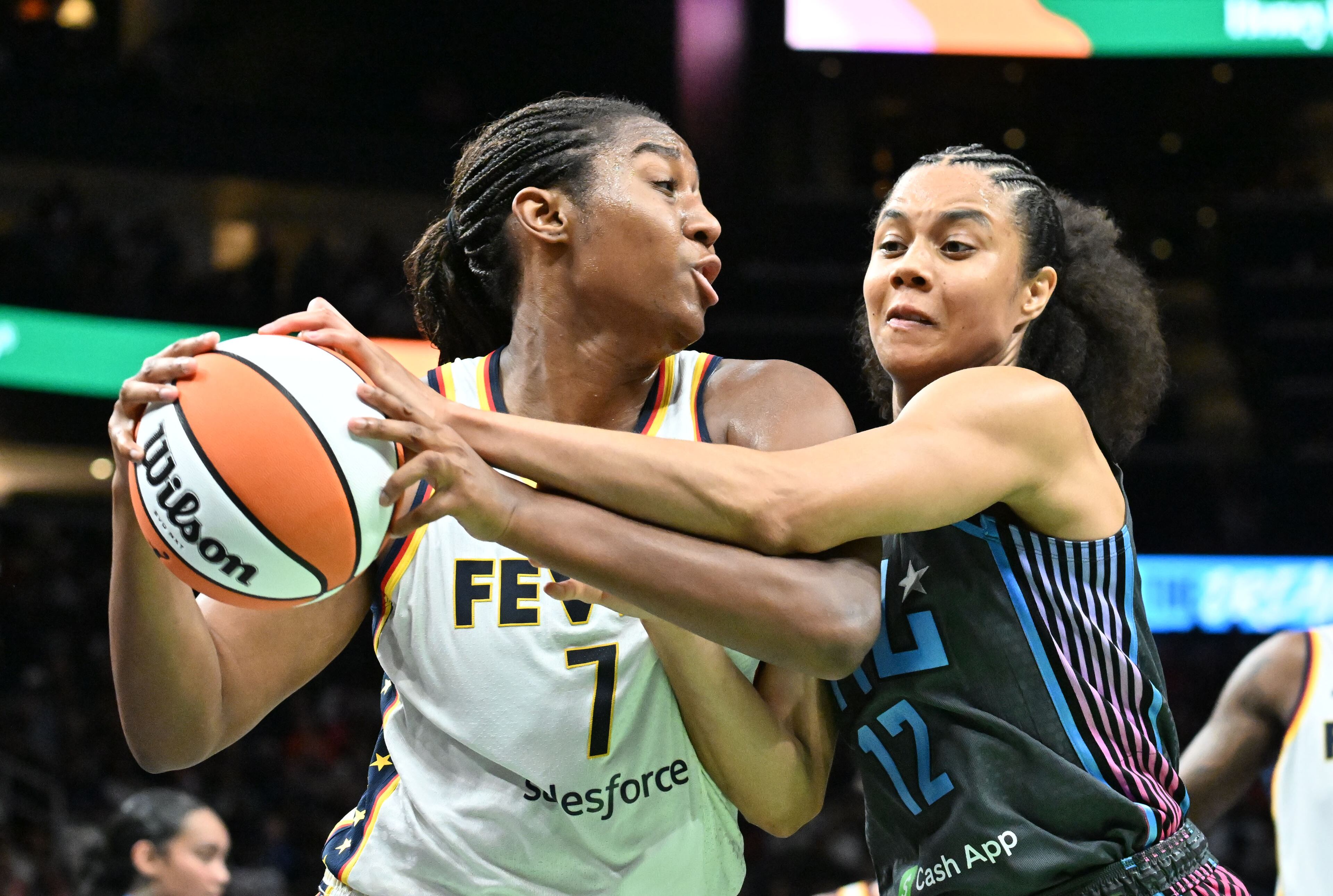 Atlanta Dream forward Nia Coffey (12) fights for a loose ball against Indiana Fever forward Aliyah Boston (7) during the second half in Atlanta Dream’s home opener at State Farm Arena, Thursday, May 22, 2025, in Atlanta. Indiana Fever won 81-76 over Atlanta Dream. (Hyosub Shin / AJC)