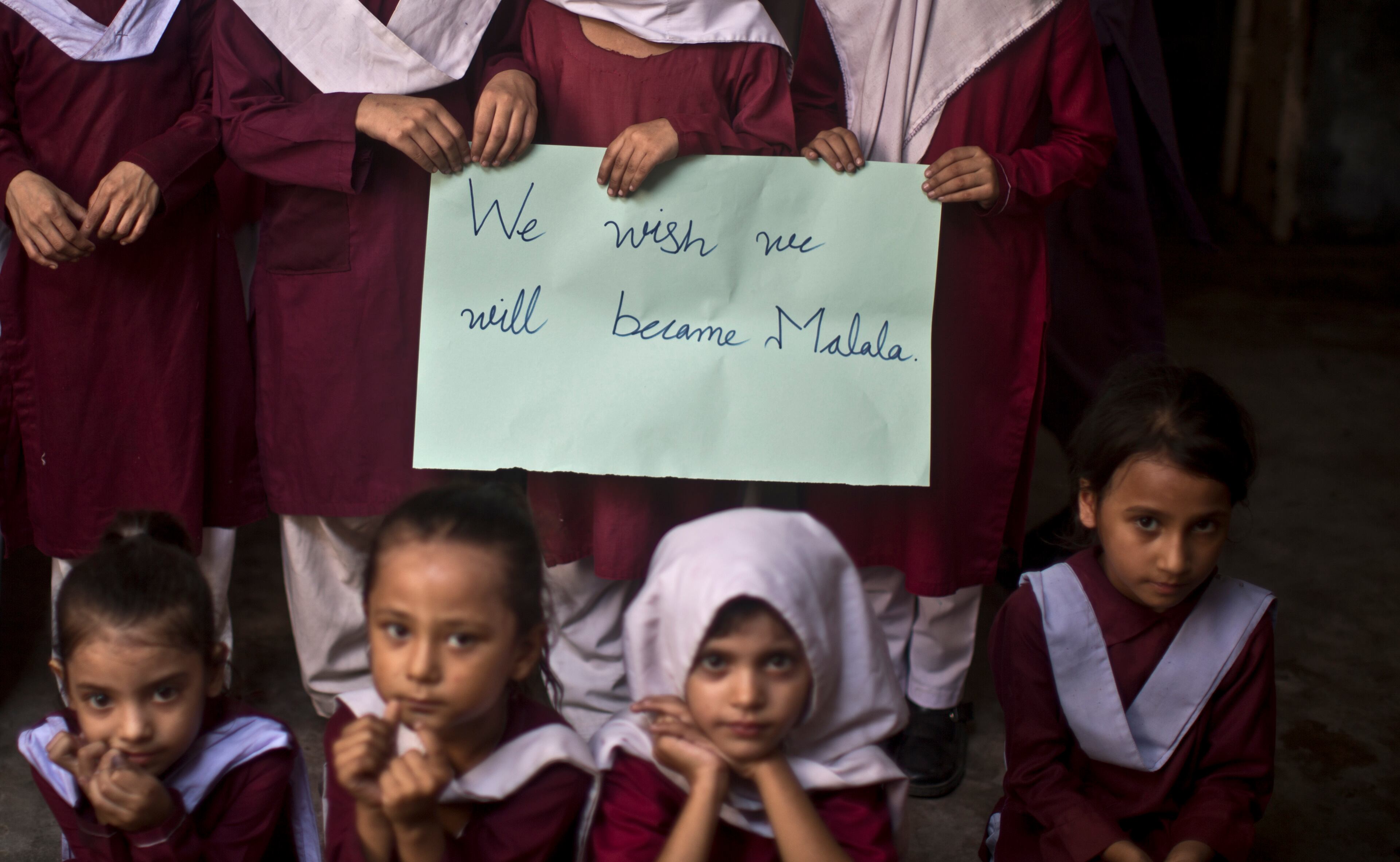 Pakistani school children hold a hand-written sign during a special class to commemorate the anniversary of Malala Yousufzai's shooting by Taliban, at a school in Rawalpindi, Pakistan, Wednesday, Oct. 9, 2013.