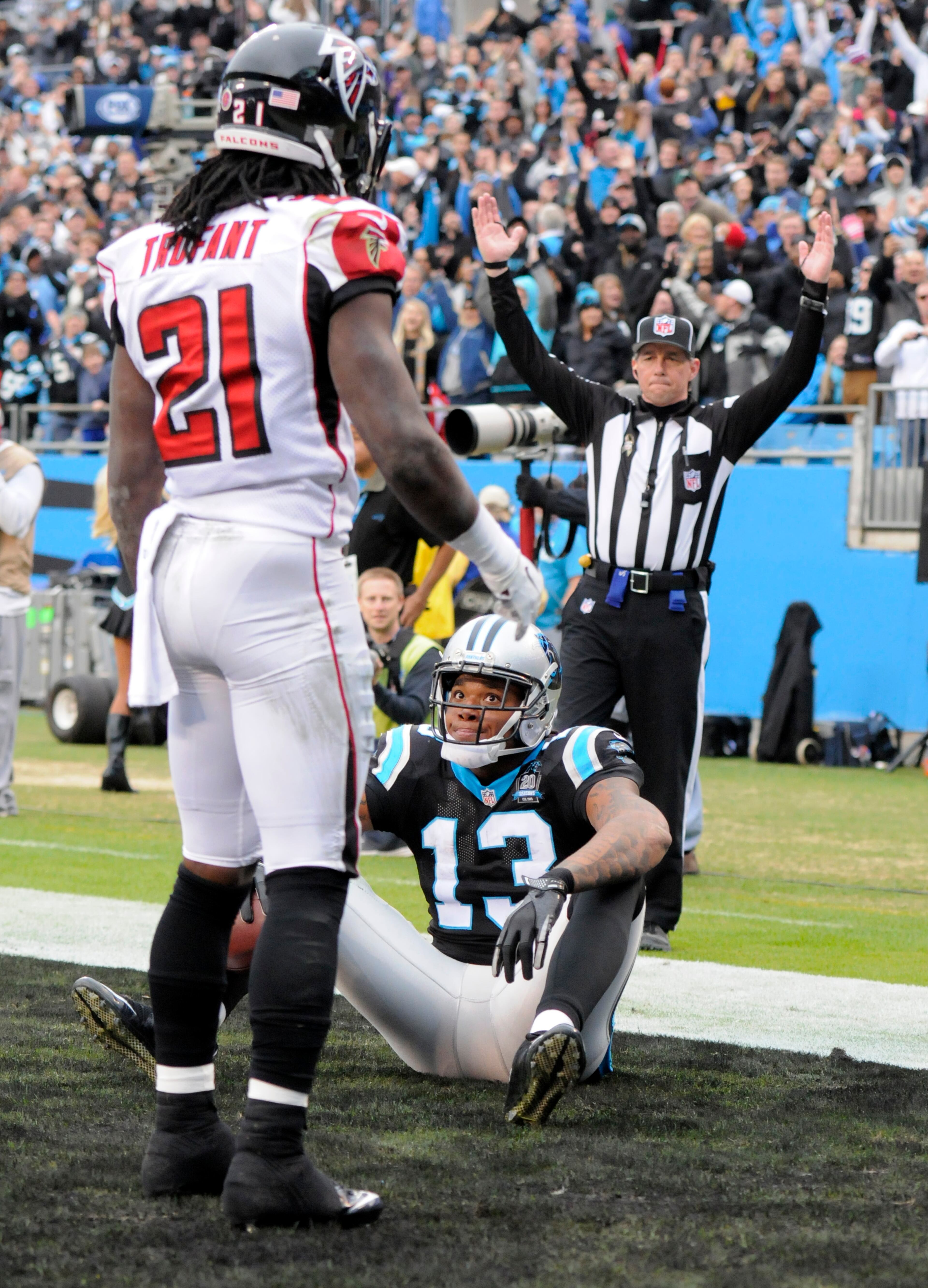 Carolina Panthers' Kelvin Benjamin (13) grins at Atlanta Falcons' Desmond Trufant (21) after catching a touchdown pass in the second half of an NFL football game in Charlotte, N.C., Sunday, Nov. 16, 2014. (AP Photo/Mike McCarn)