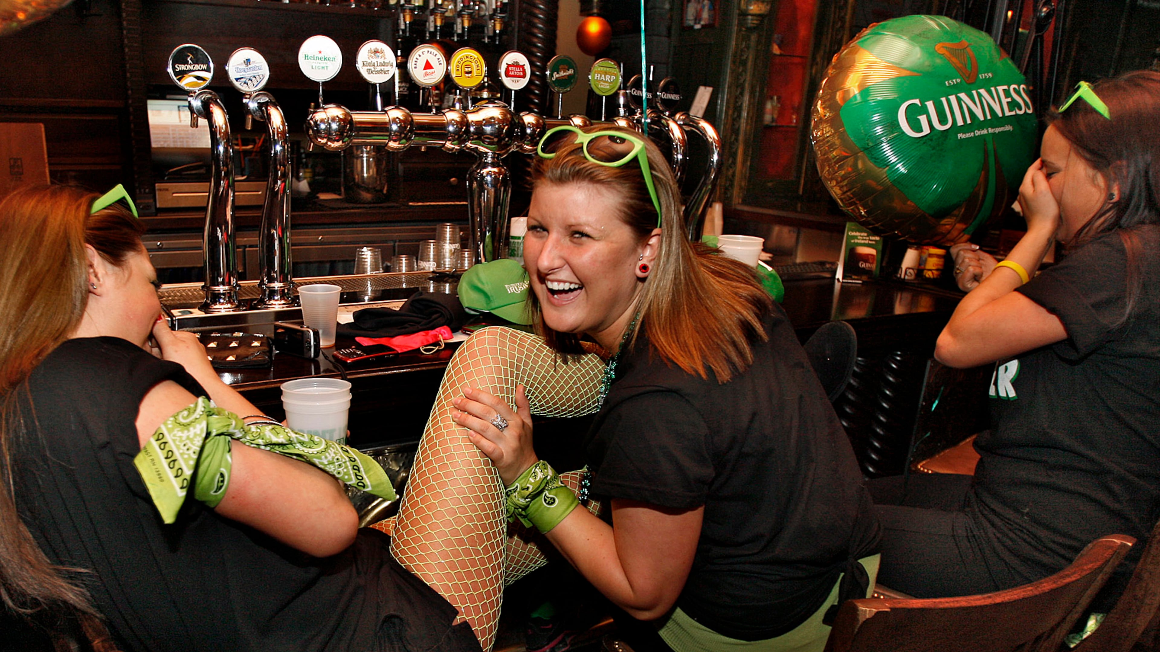 100317- Atlanta - Left to right- Courtney Berry, Ambyre McCann and Dorothy Williams all from Marietta enjoyed a laugh Wednesday as they began their St. Patrick's Day at 7:30AM at Fado Irish Pub. The trio all work together at Marietta Billiard Club and planned to continue bar hopping until 10:30PM. Fadó Irish Pub and Restaurant at 273 Buckhead Avenue in Buckhead opened its doors at 6AM Wednesday, March 17, 2010 to start off their Saint Patrick’s Day festivities. Traditional Irish breakfast was served and at Noon, bagpipes will launch the street party where 4 different bands playing a diverse range of Irish music will set the tone until 11PM when the street party shuts down. Irish dancers will also be on hand to perform. The bar will remain open until 3AM Thursday morning. The pub originally opened in 1996 and moved 2-years ago to its present location. Saint Patrick is the patron Saint of Ireland because of his evangelization of the island and has been celebrated on March 17th liturgically in most Sacramental Christian churches for centuries. Many secular versions of the celebration include celebrations in pubs and bars and parades. John Spink, jspink@ajc.com