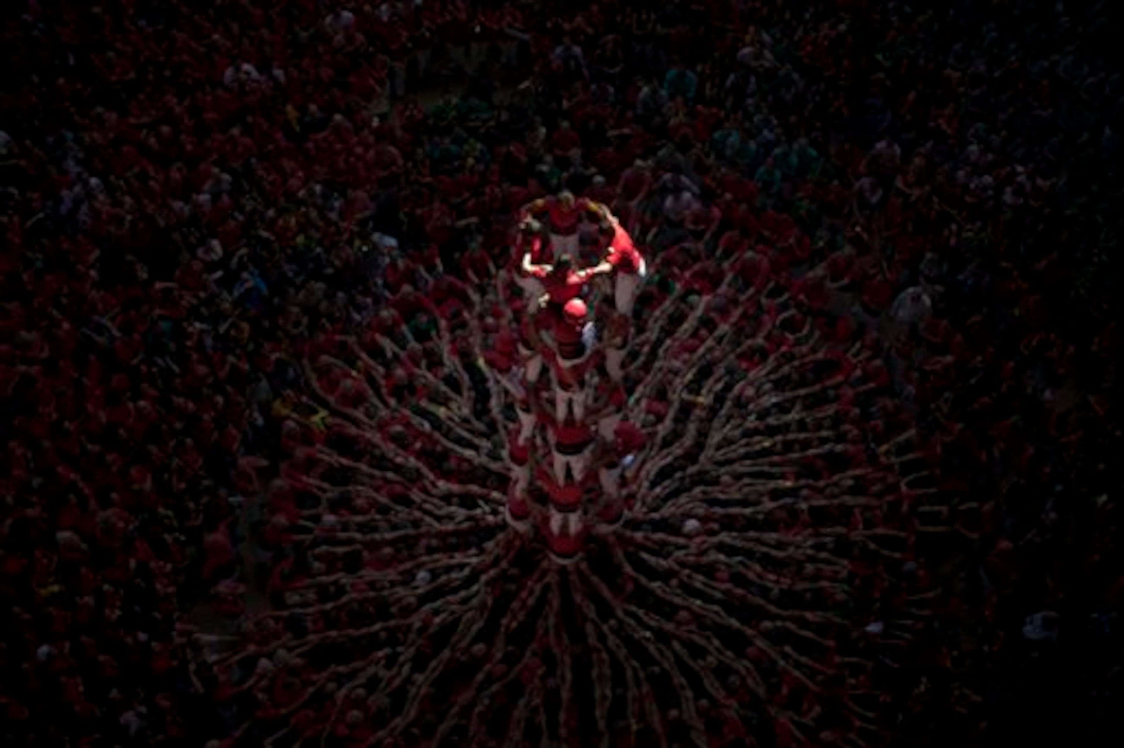 Members of the Castellers Joves Xiquets de Valls try to complete their human tower during the 25th Human Tower Competition in Tarragona, Spain, on Sunday, Oct. 5, 2014. The tradition of building human towers or �castells� dates back to the 18th century and takes place during festivals in Catalonia, where �colles� or teams compete to build the tallest and most complicated towers. The structure of the �castells� varies depending on their complexity. A �castell� is considered completely successful when it is loaded and unloaded without falling apart. The highest �castell� in history was a 10 floor structure with 3 people in each floor. In 2010 �castells� were declared by UNESCO one of the Masterpieces of the Oral and Intangible Heritage of Humanity. (AP Photo/Emilio Morenatti)