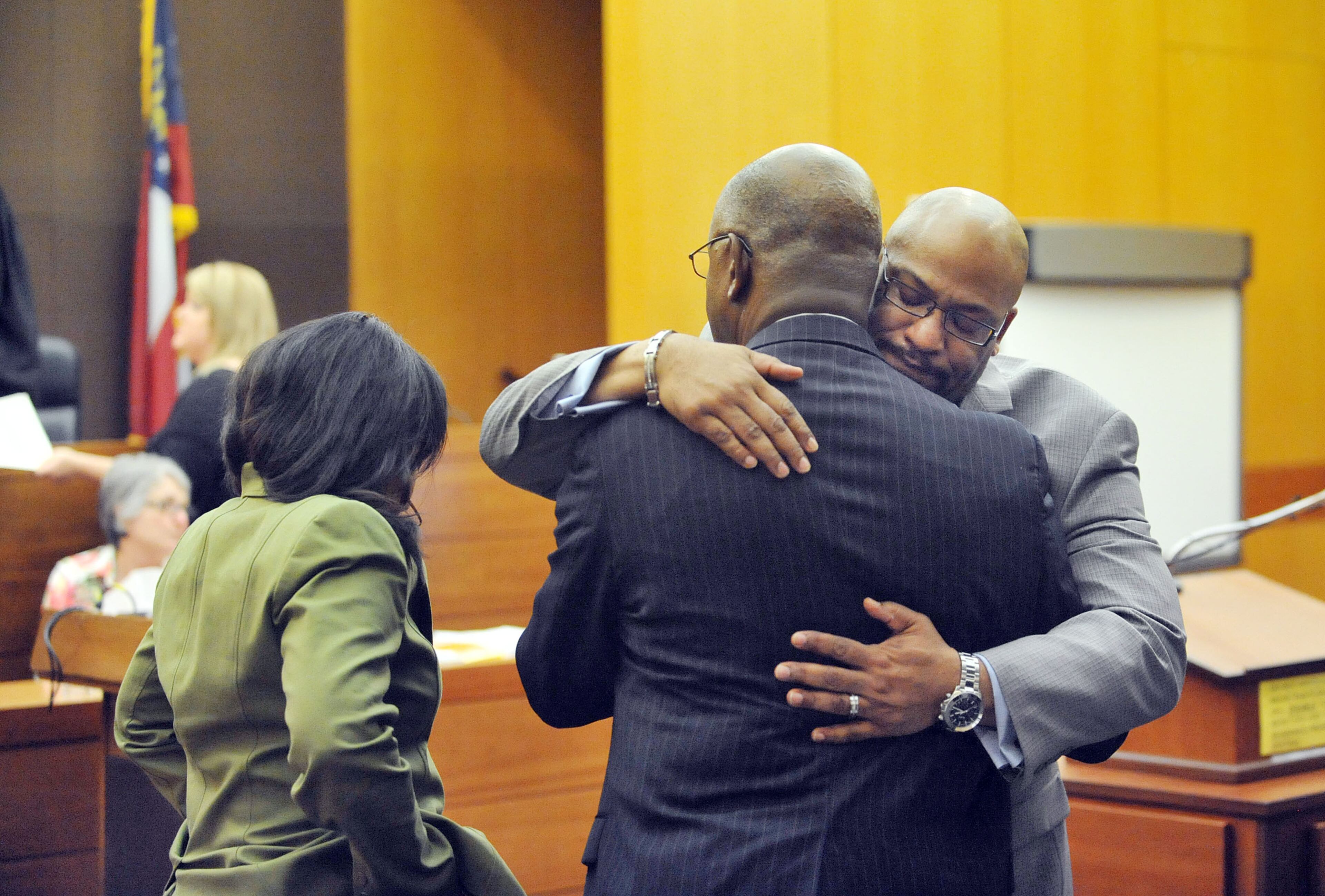 Fulton County Senior ADA Clint Rucker hugs Fulton County District Attorney Paul Howard (back to camera) after nearly every defendant was found guilty of Violation of Racketeer Influenced and Corrupt Organizations Act and lesser charges Wednesday. A jury of six men and six women rendered their verdicts on the eighth day of deliberations in the Atlanta Public Schools test-cheating trial on Wednesday, April 1, 2015. Jurors sorted through roughly five months of testimony against 12 former educators accused of engaging in a racketeering conspiracy to inflate test scores. (Atlanta Journal-Constitution, Kent D. Johnson, Pool)