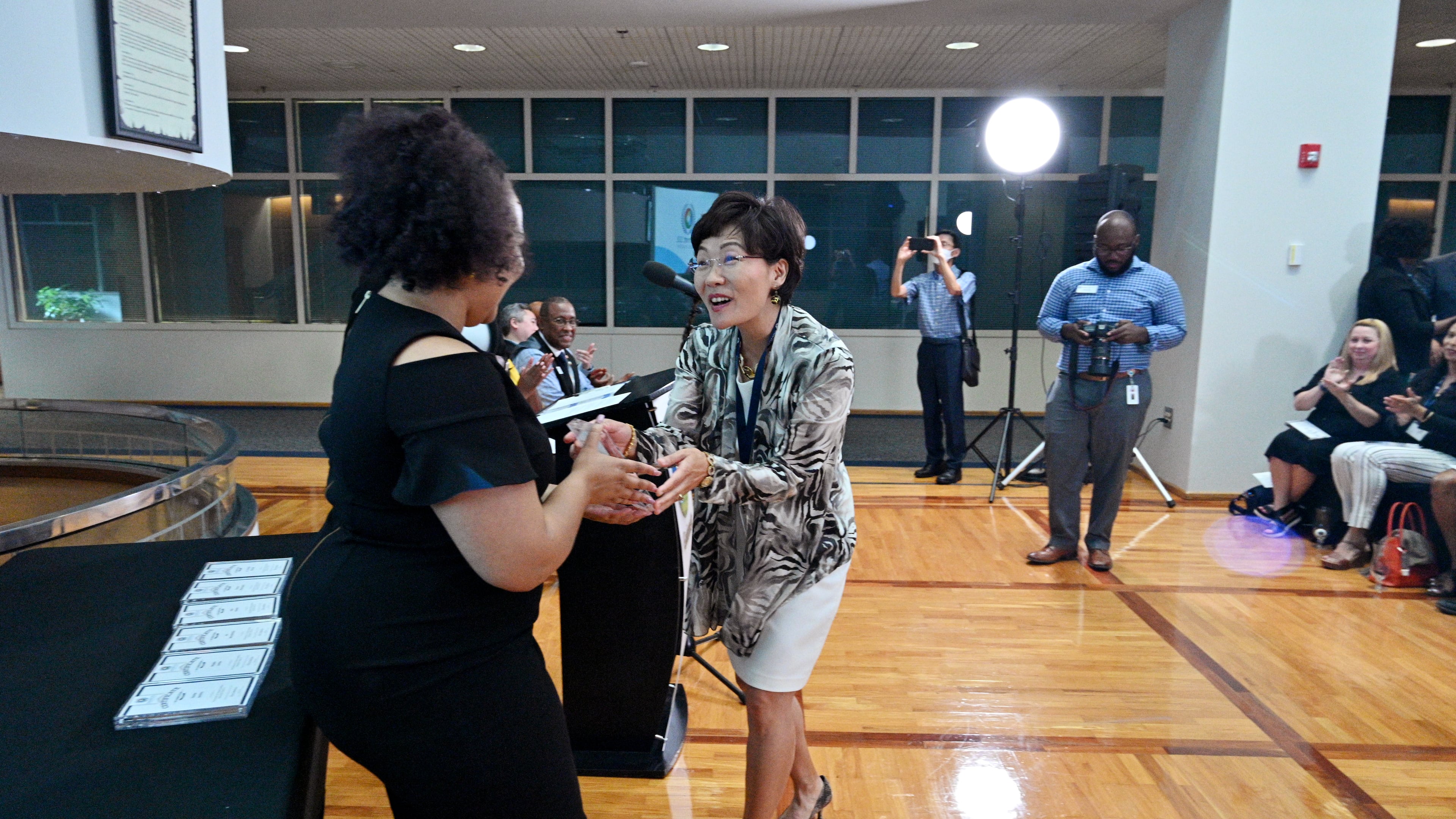 Myeong Hwa Jang reacts as she receives her certificate from Jessica Stewart, left, Community Outreach Program Manager, during Gwinnett 101 Citizens Academy's Spring 2021 graduation ceremony at Gwinnett Justice & Administration Center on Tuesday, June 22, 2021. (Hyosub Shin / Hyosub.Shin@ajc.com)