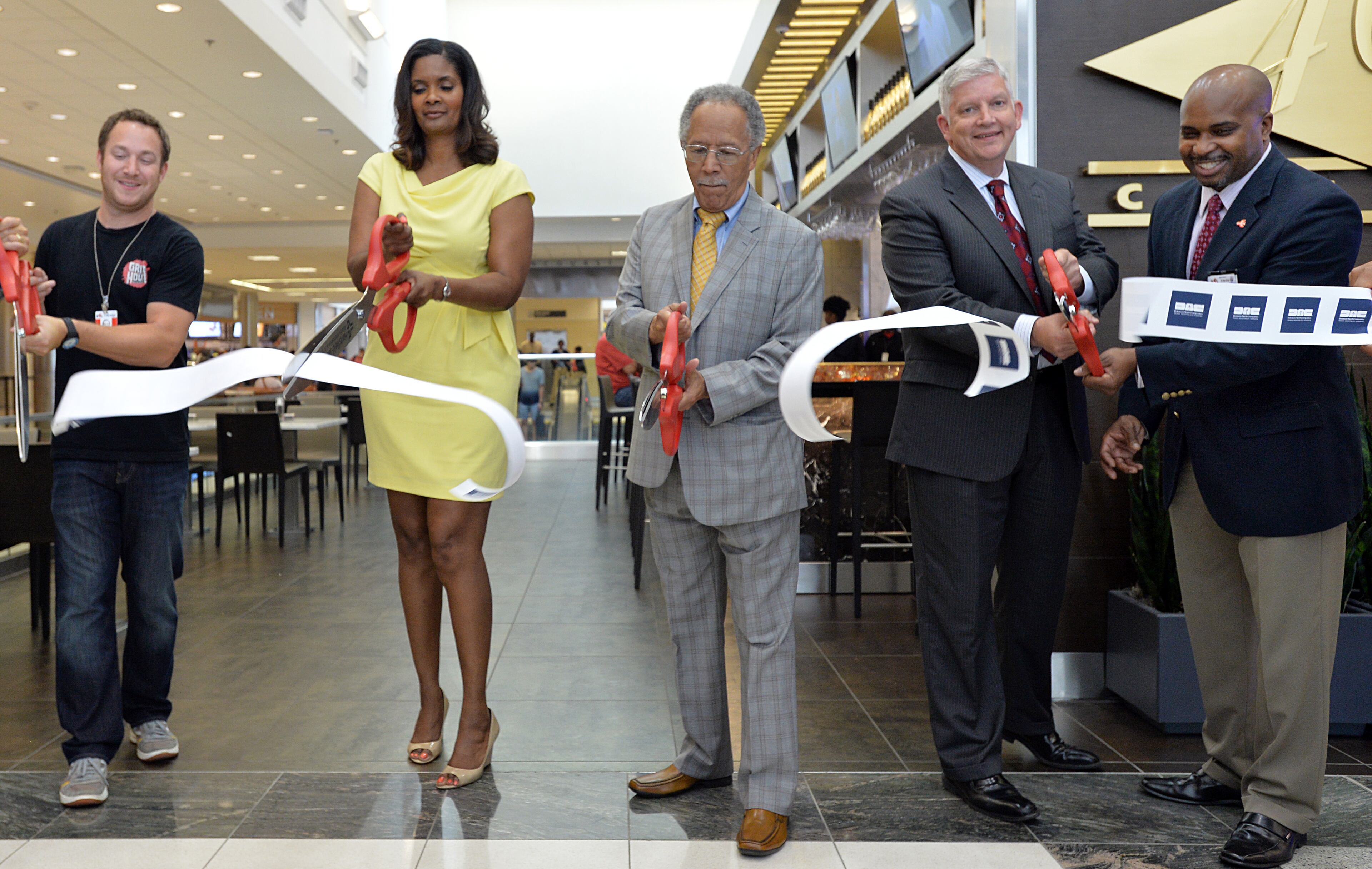 June 24, 2014 Atlanta - Vivica Brown (second from left), Interim Assistant General Manager for Hartsfield-Jackson, and other VIP guests (from left) Alex Brounstein, owner of Grindhouse Killer Burgers, C.T. Martin, Atlanta City Councilmember, Kevin Kelly, President of Delaware North Companies Travel Hospitality Services, and Paul Brown, Director of Concession for Hartsfield-Jackson, cut the ribbon during the celebration of Grand Opening of Concourse D at the Hartsfield-Jackson Atlanta International Airport on Tuesday, June 24, 2014. Hartsfield-Jackson and Delaware North celebrate the newest additions to Concourse D, including local favorites GrindHouse Killer Burgers and Yoforia, and national brands 40/40 Club and Food Network Kitchen. HYOSUB SHIN / HSHIN@AJC.COM