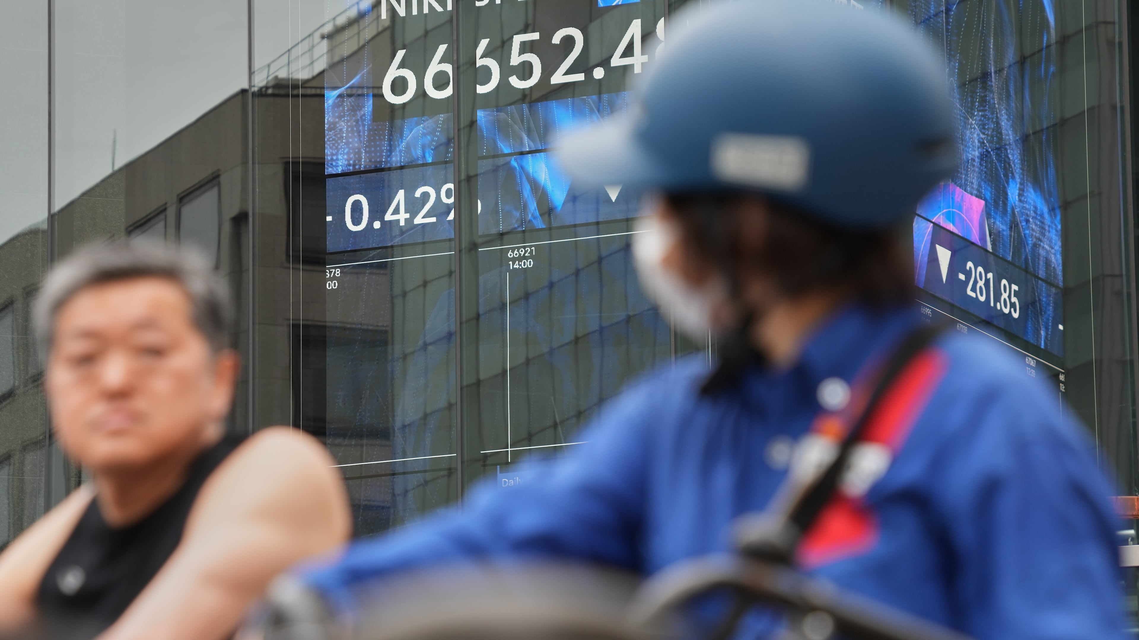 People stop in front of an electronic stock board showing Japan's Nikkei index at a securities firm Tuesday, June 2, 2026, in Tokyo. (AP Photo/Eugene Hoshiko)