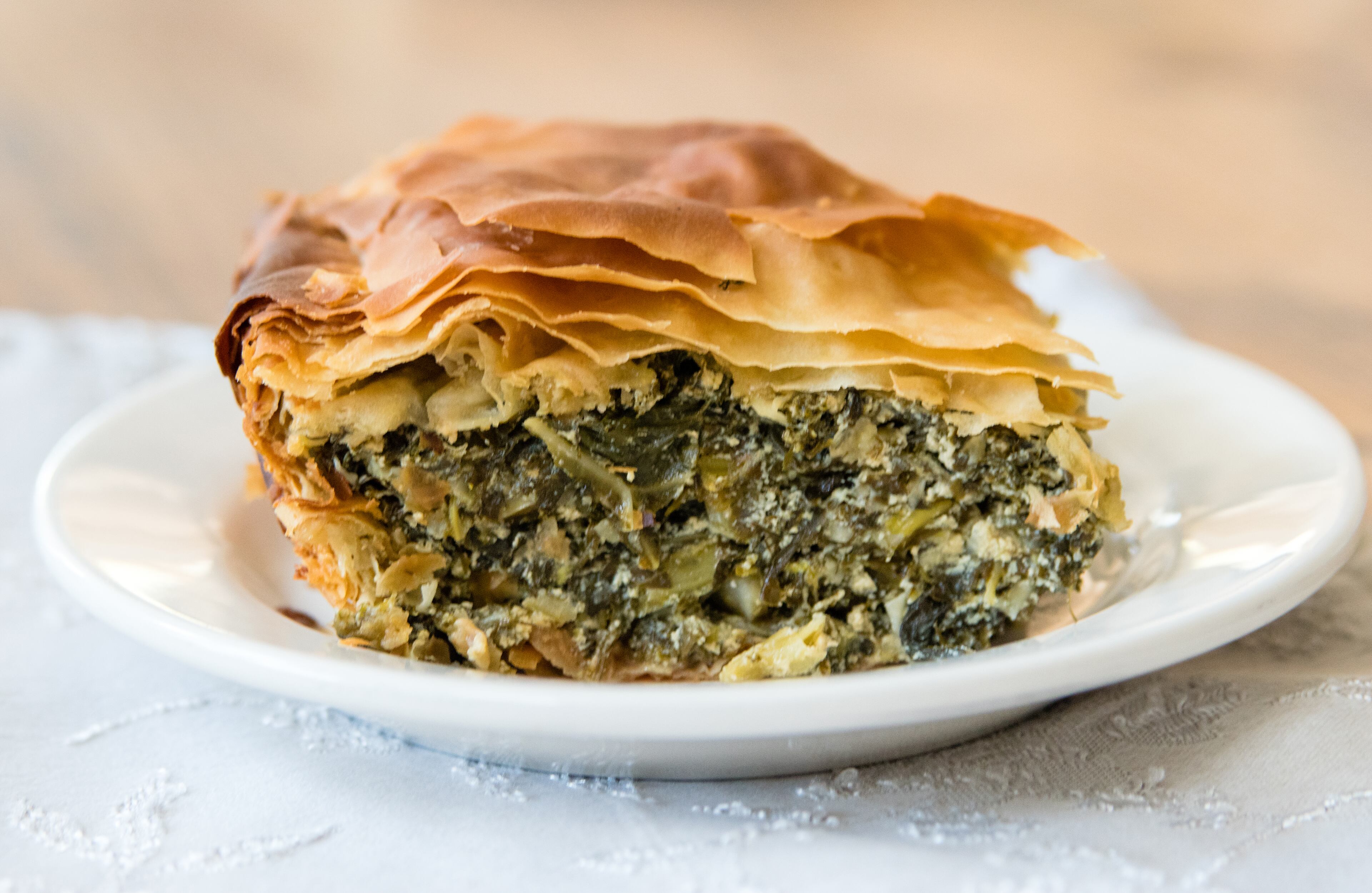 A hearty piece of spanakopita, the Greek phyllo pie made with a Southern twist: collard greens and kale have been substituted for the spinach. CONTRIBUTED BY HENRI HOLLIS