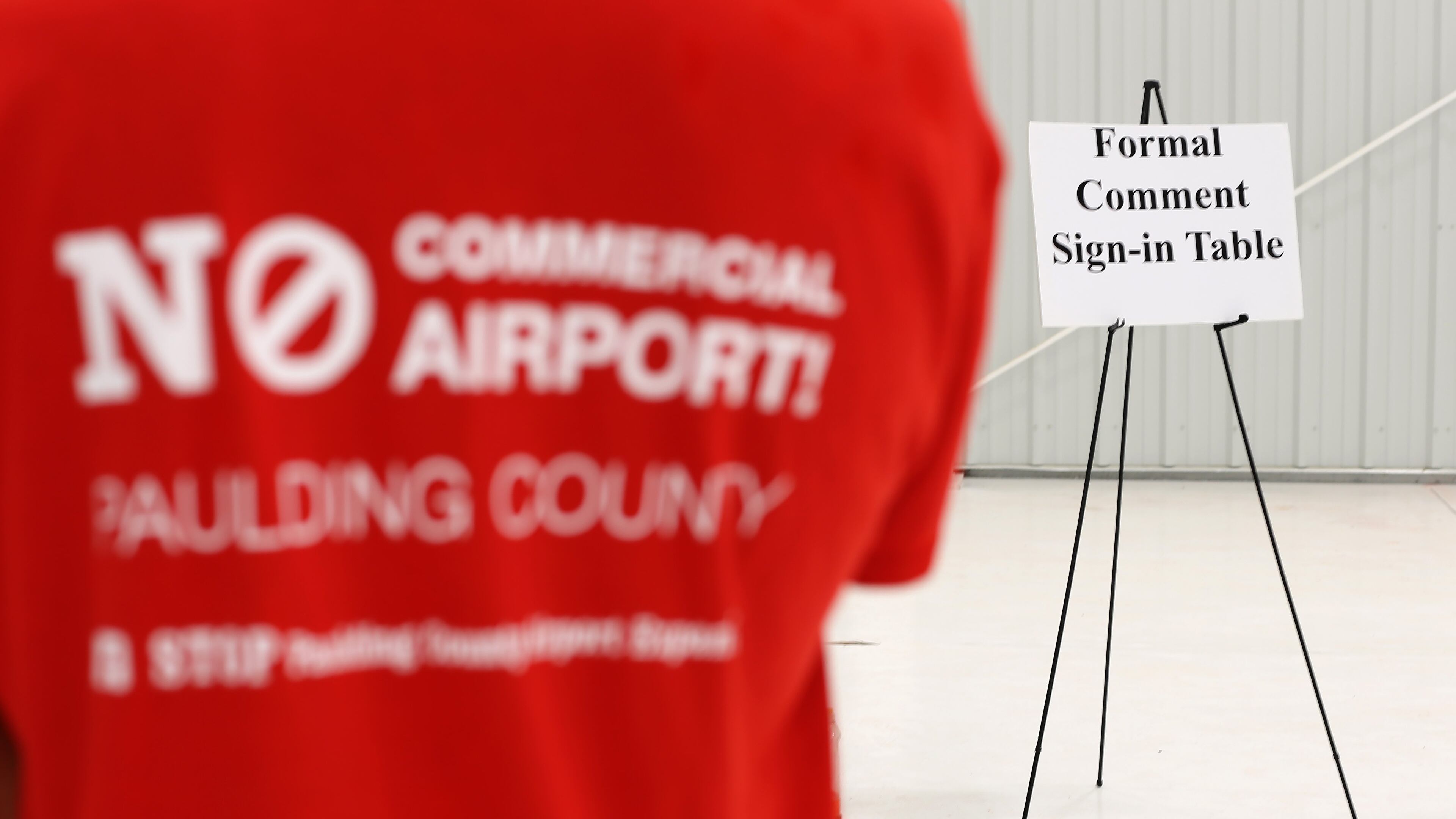 An opponent of commercializing the airport in Paulding County waits in line to sign up to speak at a December hearing. Ben Gray / bgray@ajc.com